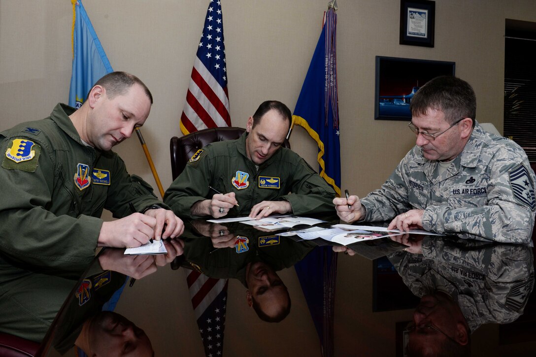 Col. Gentry Boswell, 28th Bomb Wing vice commander, (left) Col. Kevin Kennedy, 28th BW commander, and Chief Master Sgt. Kevin Peterson, 28th BW command chief, sign the first donation slips for the 2014 Air Force Assistance Fund campaign at Ellsworth Air Force Base, S.D., March 17, 2014. The AFAF campaign provides Airmen with an opportunity to donate to charities benefiting active duty, retired, office and enlisted Airmen. (U.S. Air Force photo by Airman 1st Class Rebecca Imwalle/ Released)