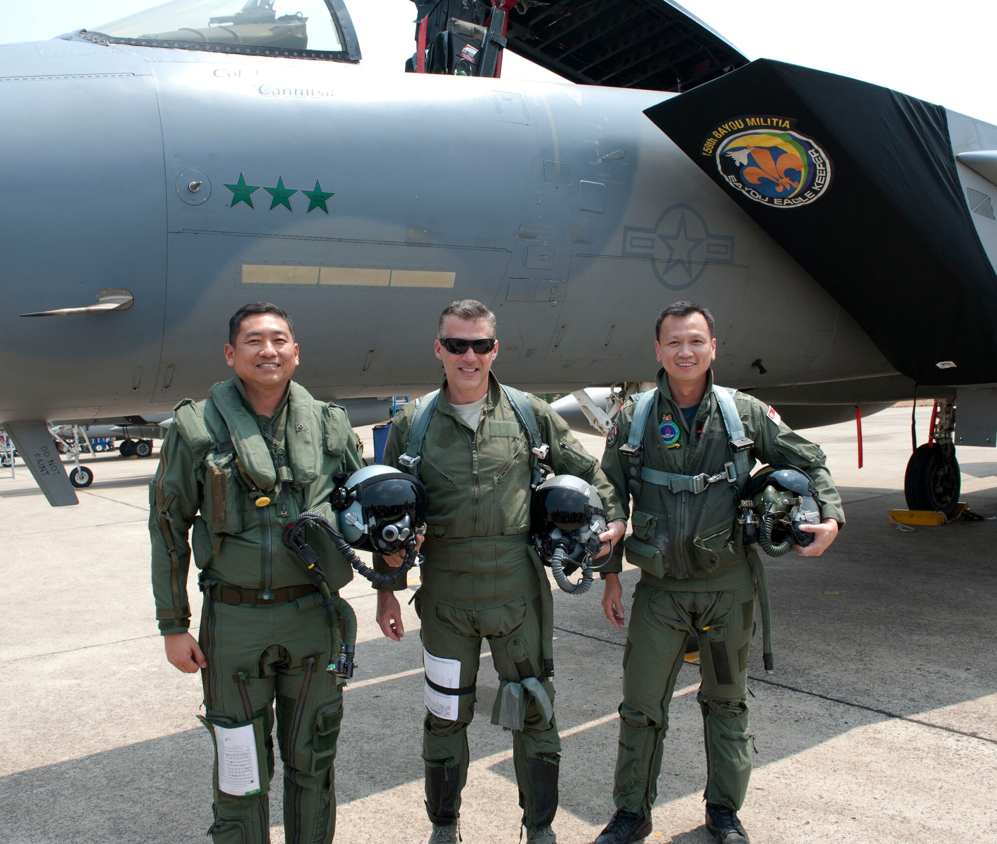 Air Force Col. John Traettino, U.S. Cope Tiger Exercise Director 2014, poses on the flight line at Korat Royal Thai Air Force Base, Thailand with his counterparts from the Republic of Singapore and Royal Thai air forces. Cope Tiger is an annual, multilateral aerial exercise in Thailand to improve combat readiness, interoperability and build relations between Thailand, Singapore and the United States. (U.S. Air Force photo by 2Lt. Michael Harrington/Released)