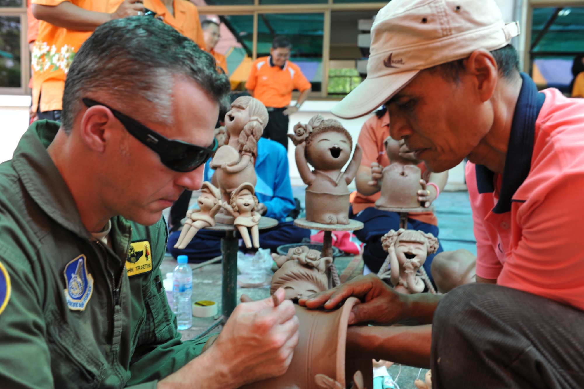 Air Force Col. John Traettino, U.S. exercise director for Cope Tiger 2014, etches in clay in a pottery demonstration at Dwan Kwian Witthaya School near Korat, Thailand. The pottery was part of an engagement with the Dan Kwian Witthaya School, where U.S., Singapore and Thai Air Force members offered community medical and dental services and exchanged cultures with the local school children as part of exercise Cope Tiger 2014. (U.S. Air Force photo by 2Lt. Michael Harrington/Released)