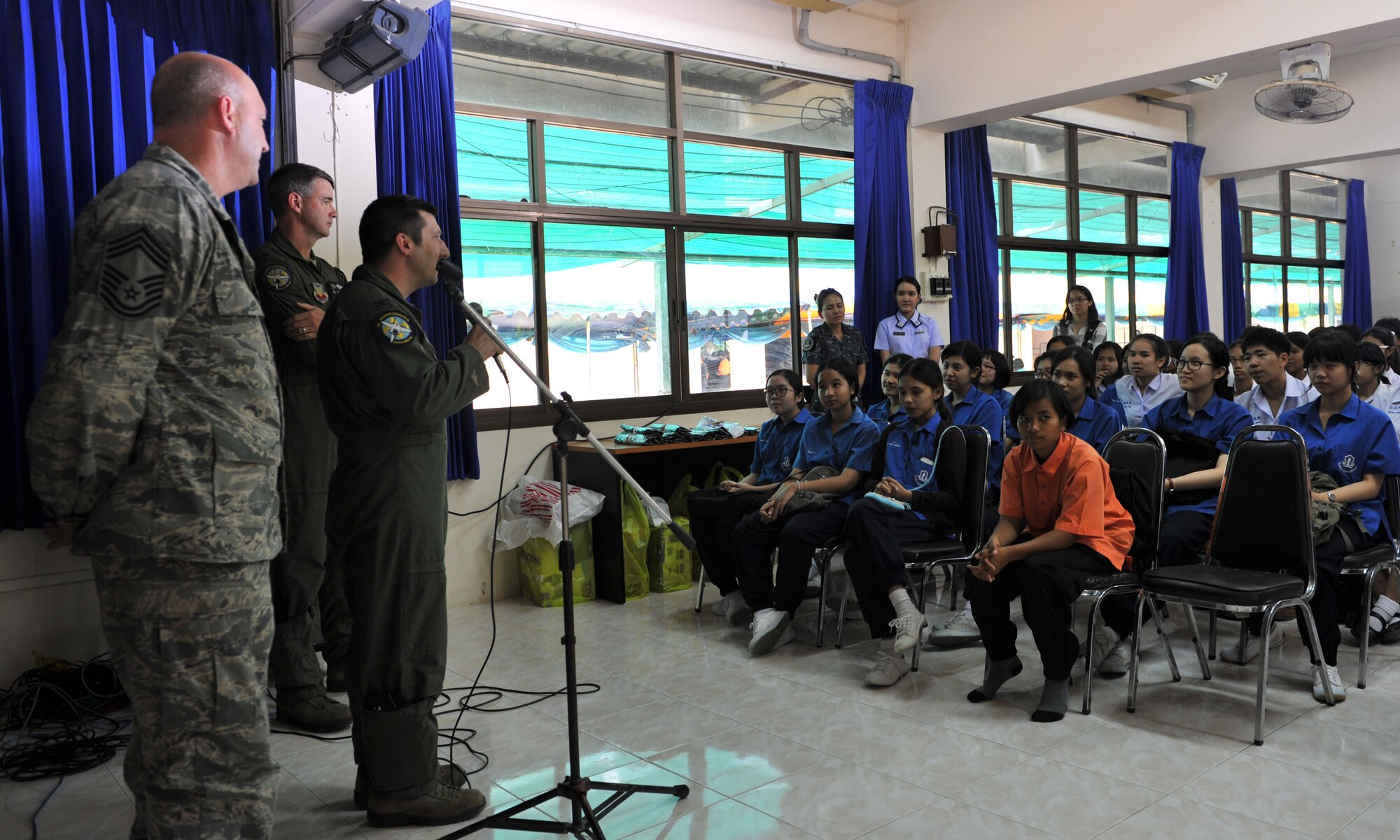 Air Force Col. Tony DiCarlo, Cope Tiger 2014 detachment commander speaks to Thai students while Col. Roy Qualls, F-15 pilot and Chief Master Sgt. Brian Cooper, exercise non-commissioned officer-in-charge, look on. The talk was part of an engagement with the Dan Kwian Witthaya School, where U.S., Singapore and Thai Air Force members offered community medical and dental services and exchanged cultures with the local school children as part of exercise Cope Tiger 2014. (U.S. Air Force photo by 2Lt. Michael Harrington/Released)