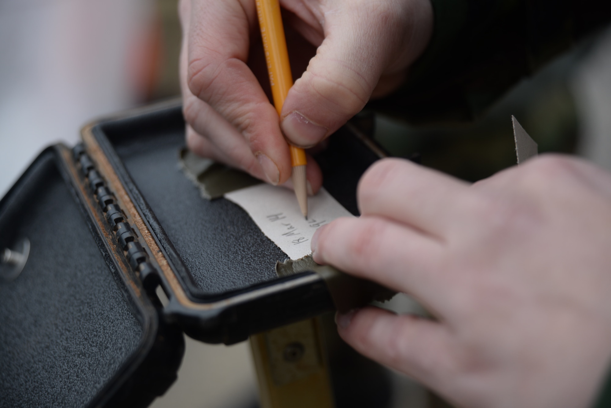 An Airman writes the date and time on a piece of M8 paper during chemical, biological, radioactive, and nuclear training, Shaw Air Force Base, S.C., March 18, 2014. Twenty-four Airmen tested their skills during a CBRN course to prepare for upcoming deployments. (U.S. Air Force photo by Airman 1st Class Michael A. Cossaboom/Released) 