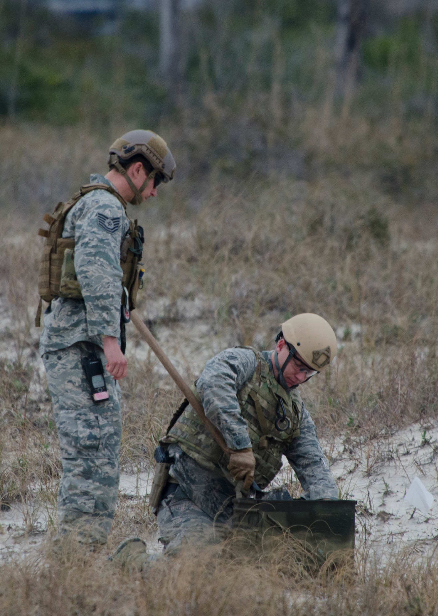 Tech. Sgt. Brian Dunnagan, 1st Special Operations Civil Engineer Squadron explosive ordnance disposal craftsman, and Senior Airman Christopher Dolan, 919th Special Operations Squadron explosive ordnance journeyman, place an unexploded ordnance into an ammo can at Perdido Key, Fla., March 12, 2014. EOD Airmen used C4 to dispose of an unexploded ordnances.  (U.S. Air Force photo/Staff Sgt. John Bainter)