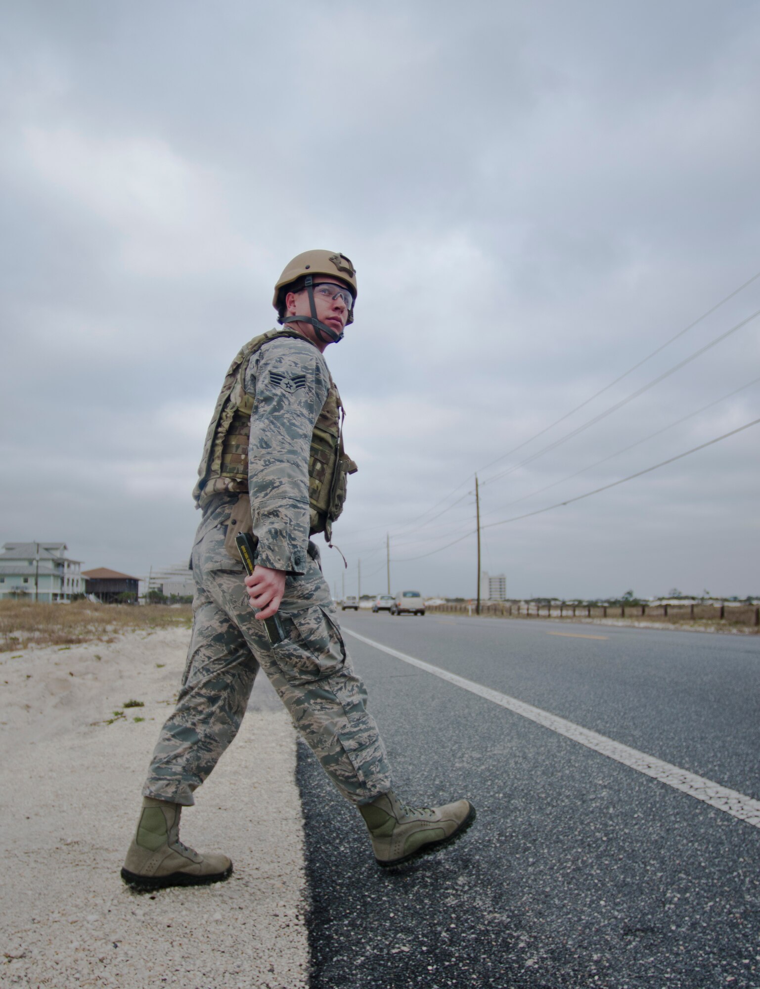 Senior Airman Christopher Dolan, 919th Special Operations Squadron explosive ordnance journeyman, crosses the street carrying a stick of C4 explosive at Perdido Key, Fla., March 12, 2014. EOD Airmen used C4 to dispose of an unexploded ordnances. (U.S. Air Force photo/Staff Sgt. John Bainter)