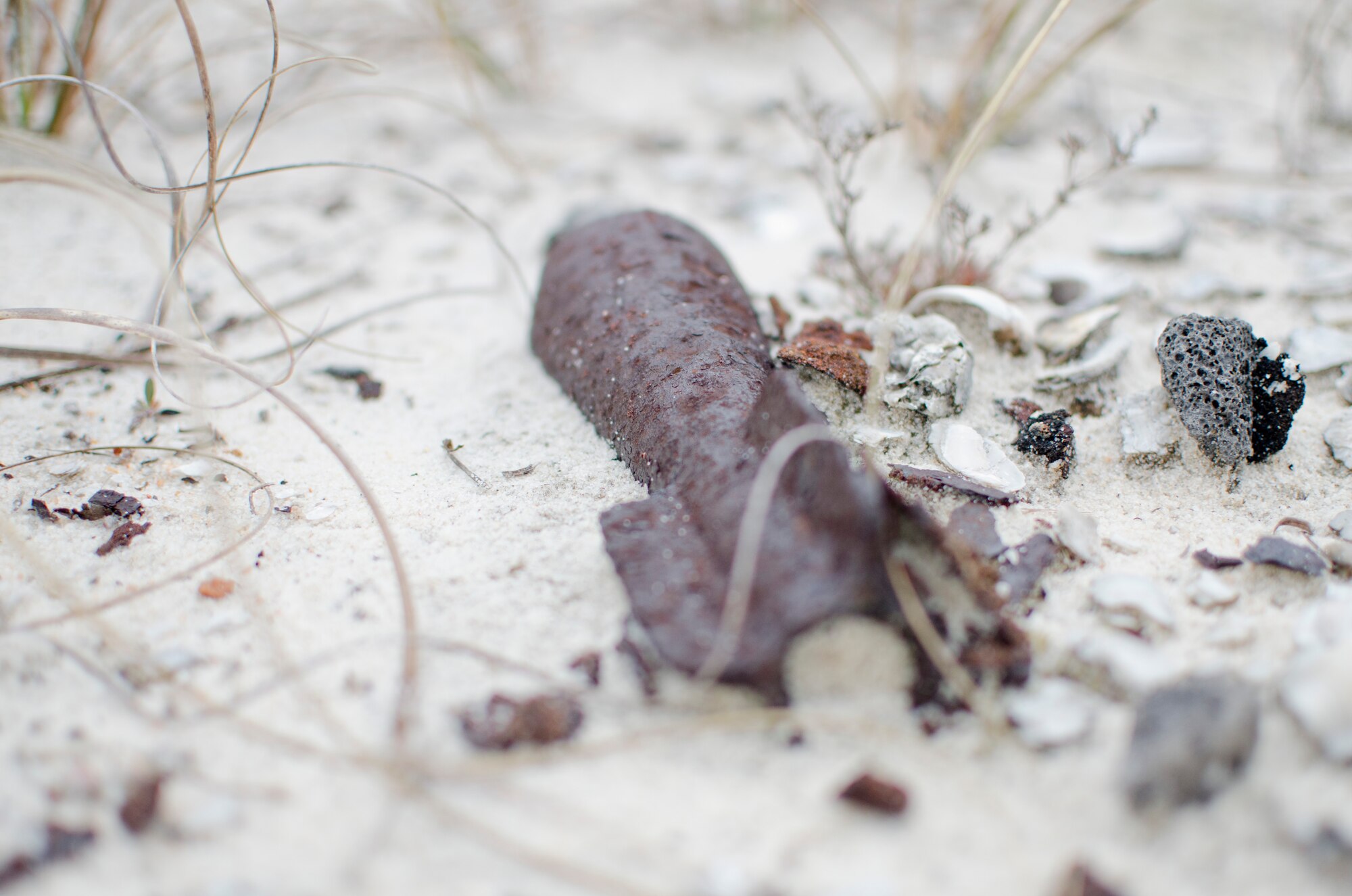 An unexploded ordnance sits in the sand at Perdido Key, Fla., March 12, 2014. UXOs washed ashore from military training, which took place off the coast. They can be extremely dangerous if disturbed. (U.S. Air Force photo/Staff Sgt. John Bainter)