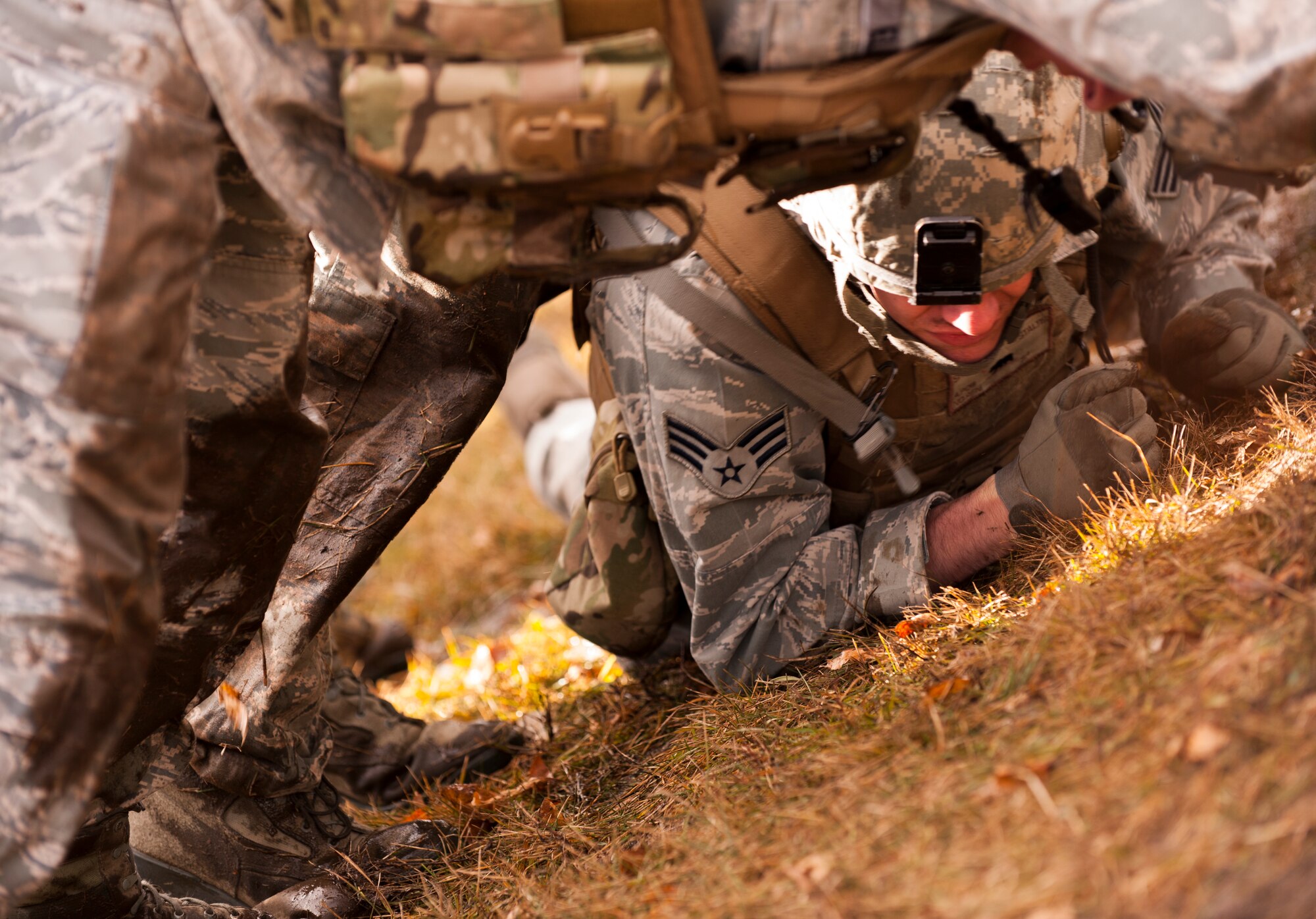 Senior Airman Dwight Stalter, 91st Missile Security Forces Squadron defender, crawls under his flight members during the Top Dog competition at Minot Air Force Base, N.D., March 12, 2014. The friendly competition allows defenders to practice training techniques while boosting morale. (U.S. Air Force photo/Airman 1st Class Apryl Hall)