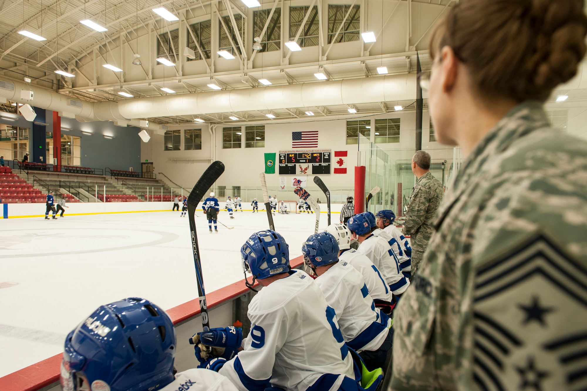 Honorary coaches Chief Master Sgt. Wendy Hansen and Col. Brian Newberry watch as their team defends the goal during a Blue vs. White Fairchild Falcons Varsity Hockey team game with base leadership coaching at Eastern Washington University’s University Recreation Center in Cheney, Wash., March 14, 2014. (U.S. Air Force photo by Staff Sgt. Benjamin W. Stratton/Released)