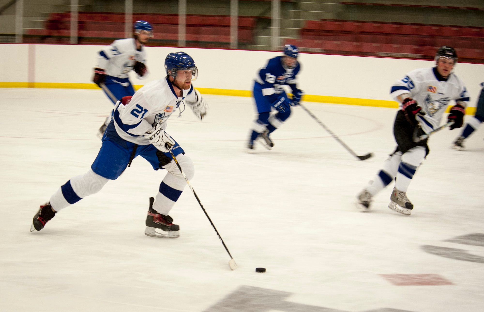 The White team drives the puck down the ice during a Blue vs. White Fairchild Falcons Varsity Hockey team game at Eastern Washington University’s University Recreation Center in Cheney, Wash., March 14, 2014. (U.S. Air Force photo by Staff Sgt. Benjamin W. Stratton/Released)
