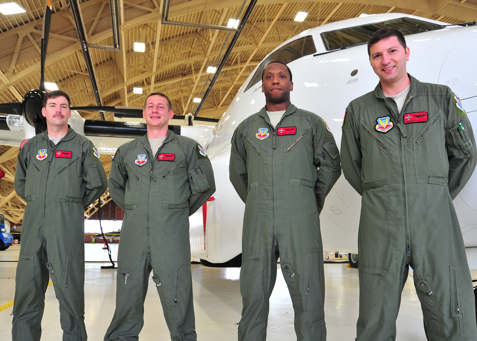 The 82nd Aerial Target Squadron team stands in front of an E-9A Widget March 17, at Tyndall’s Hanger 5. The four-man team helped locate a boat in distress that was taking in water, which led to the rescue of four sailors. (U.S. Air Force photo by Airman 1st Class Sergio A. Gamboa)