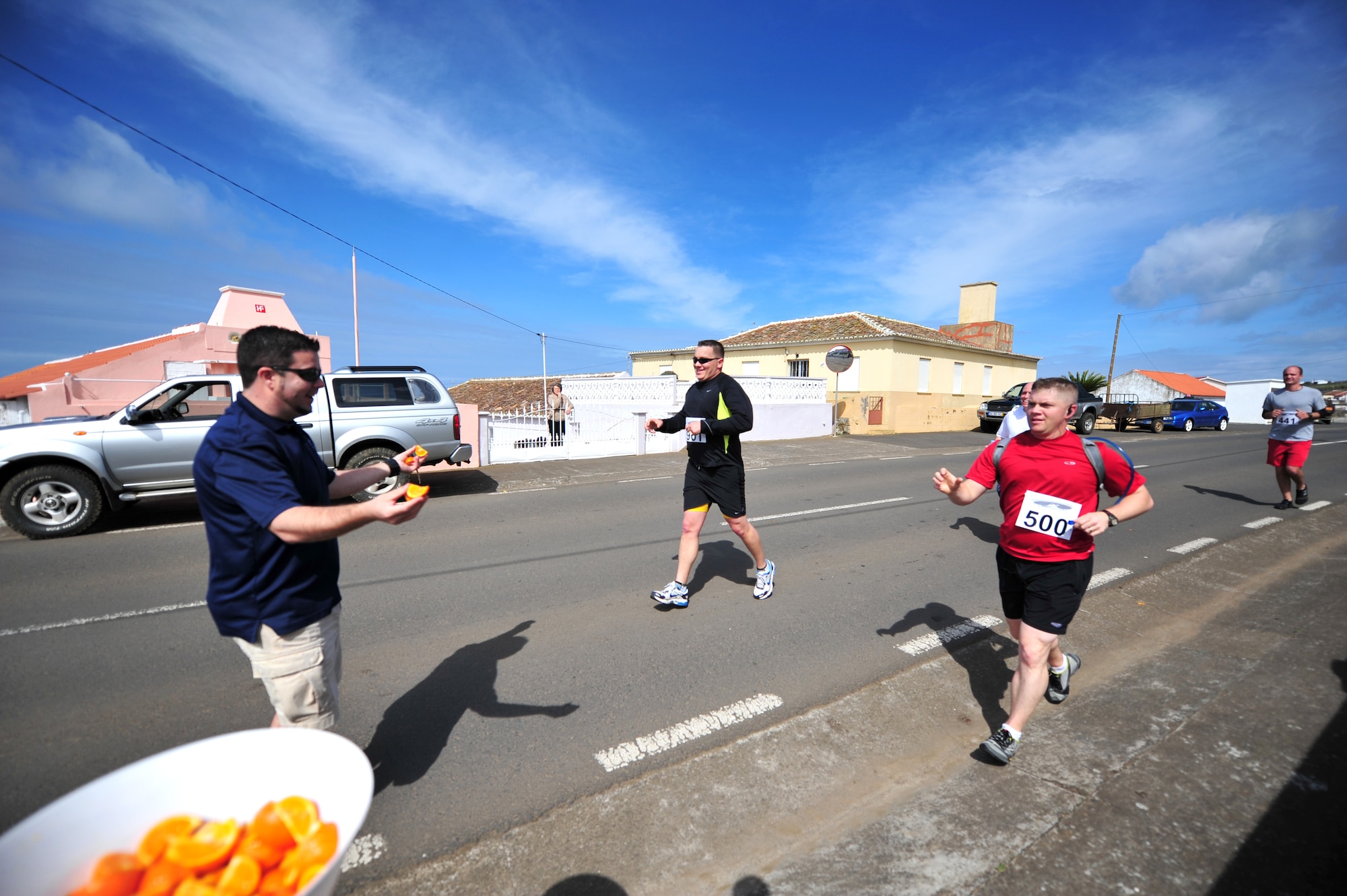 Agostinho Silva, 65th Force Support Squadron fitness and sports acting director, hands out orange slices to runners during a half marathon, May 1, 2013, Sao Mateus, Azores. For the second year in a row, the 65th FSS was awarded the Maj. Gen. Eugene L. Eubank Award at the Air Force level for 2013. They won the same award at the U.S. Air Forces in Europe level in 2011, 2012 and 2013. (U.S. Air Force photo by Tech. Sgt. Chenzira Mallory/released)