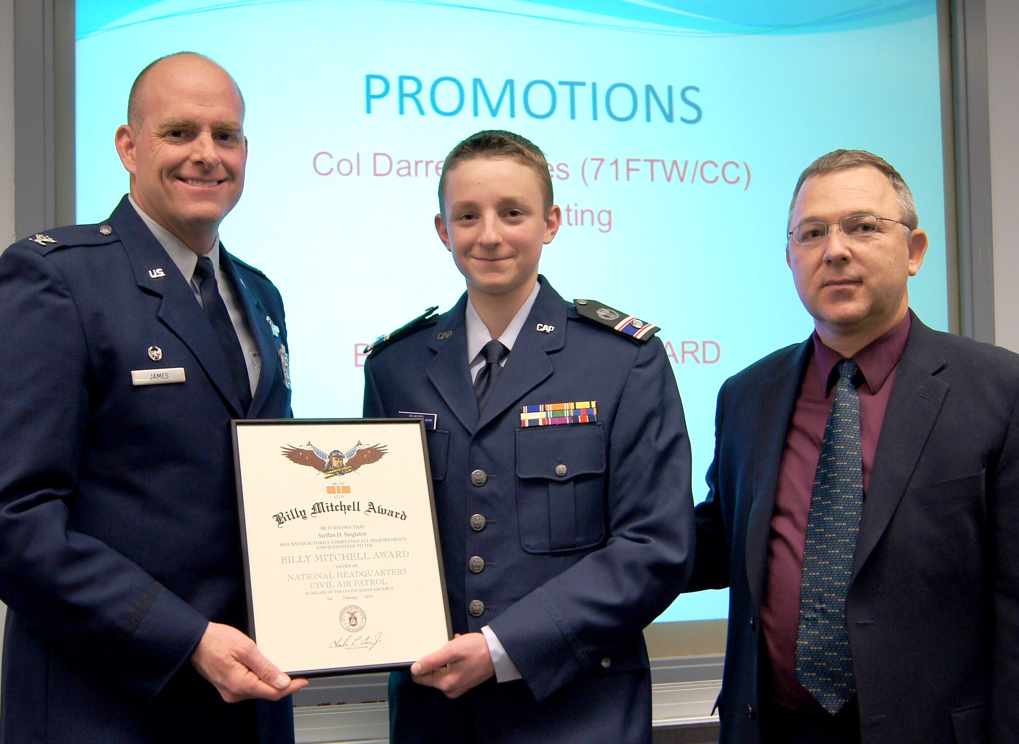 Civil Air Patrol Cadet Steffen Singleton, center, is presented the Gen. Billy Mitchell Award by Air Force Col. Darren James, left, 71st Flying Training Wing commander at Vance Air Force Base, Okla. Singleton’s father, Russell Singleton, participated in the ceremony. (Courtesy photo)