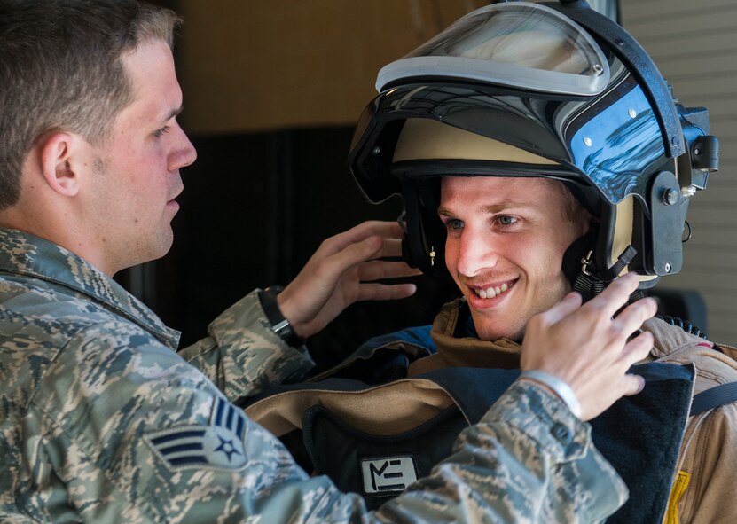 U.S. Air Force Senior Airman Rockwood Bullard, 23d Civil Engineer Squadron explosives ordnance disposal journeyman, fastens an EOD 9 bomb suit helmet on David Riffle, U.S. Air Force Reserve Officer Training Corps cadet, at Moody Air Force Base, Ga., March 14, 2014. ROTC cadets from the University of Florida toured various units from Moody to obtain a glimpse of the operational Air Force. (U.S. Air Force photo by Senior Airman Douglas Ellis/Released)
