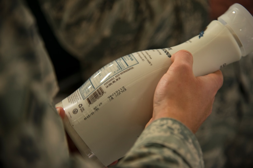 An Airman reads the nutritional facts label on a bottle of milk March 13, 2014, at the Commissary on Joint Base Charleston – Air Base, S.C. Instead of physical training for the day, Airmen from the 628th Contracting Squadron learned about nutrition in an event  hosted by the HAWC, where they were informed on how to shop and eat healthier. (U.S. Air Force photo/ Airman 1st Class Clayton Cupit)