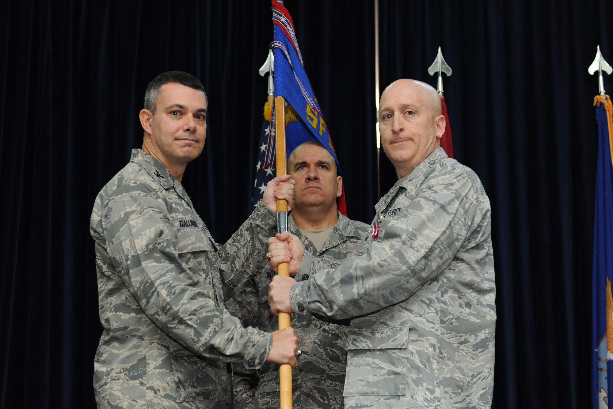 Lt. Col. Lee Curoe, 39th Security Forces Squadron commander, relinquishes command by passing the squadron's guidon to Col. Sean Gallagher, 39th Mission Support Group commander during the the 39th SFS change of command ceremony March 17, 2014, Incirlik Air Base, Turkey. The ceremony signified the transition of command from Curoe to Lt. Col. Joseph Musacchia. (U.S. Air Force photo by Senior Airman Nicole Sikorski/Released) 