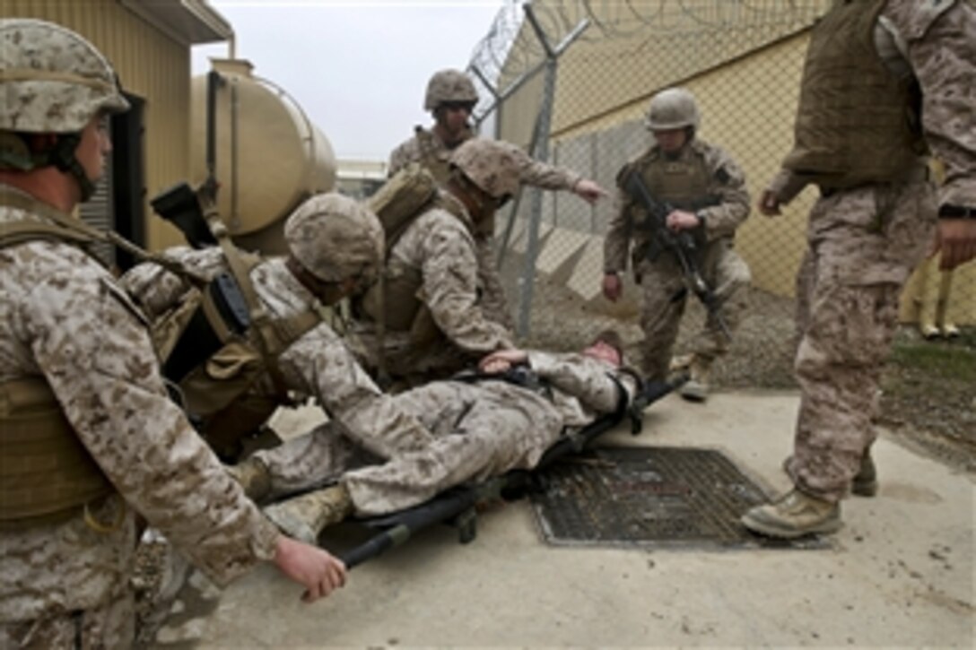 U.S. Marines and Navy corpsmen treat a simulated casualty during a training drill on Camp Leatherneck, Afghanistan, March 14, 2014. The troops are assigned to Headquarters and Service Company, 1st Battalion, 7th Marine Regiment. During the training, Navy corpsmen evaluated service members as they reacted to the situation.