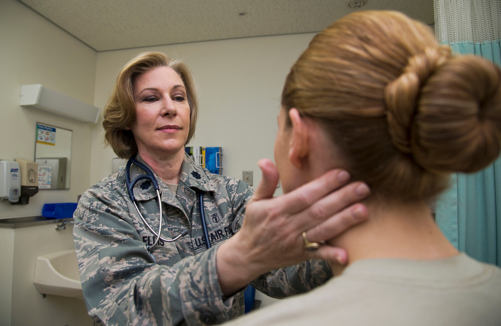 Lt. Col. Melanie Ellis, 35th Medical Operations Squadron commander, examines a patient at Misawa Air Base, Japan, Mar. 14, 2014. Ellis is being recognized for her mentorship, experience and countless accomplishments in her 20-year career as a physician assistant. (U.S. Air Force photo/Tech. Sgt. Araceli Alarcon)