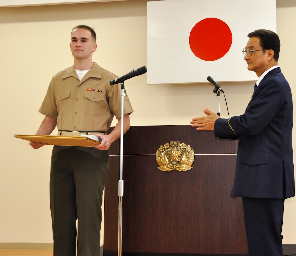 Kojin Chibana, right, applauds Lance Cpl. Steven T. Danisi, left, during an award ceremony Feb. 26 at the Okinawa Police Station in Okinawa City. Danisi was one of six Marines to receive an award for their immediate response to the Jan. 13 wreck that occurred near Zukeran Elementary School in Kitanakagusuku Village. Chibana is the chief of the Okinawa Police Station. Danisi is an accident investigator with the accident investigation section, Provost Marshal’s Office, Marine Corps Base Camp Smedley D. Butler, Marine Corps Installations Pacific. (U.S. Marine Corps photo by Hiroko Tamaki)