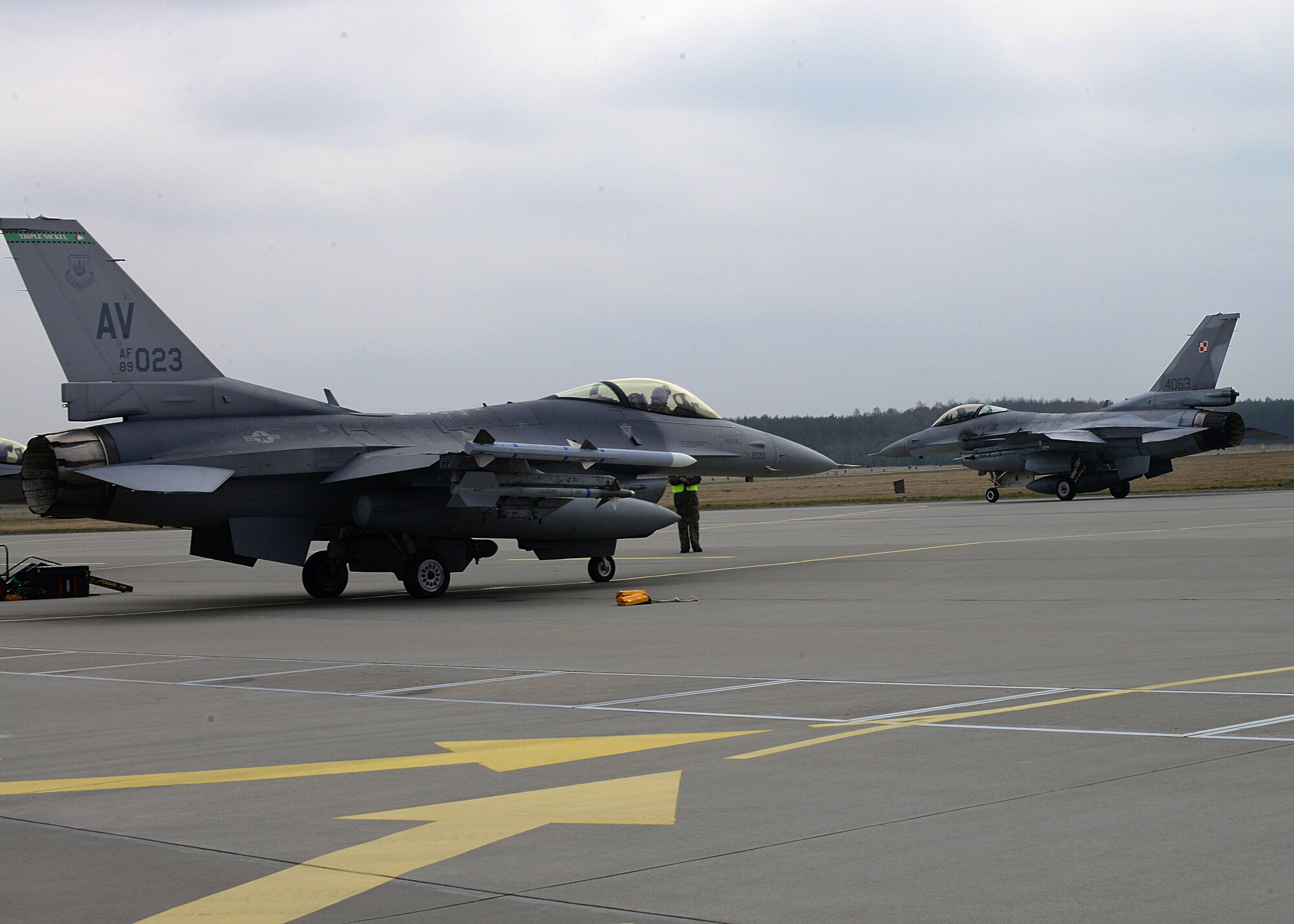 (From right) A Polish F-16 Fighting Falcon taxis past a 555th Fighter Squadron F-16 before a training mission, March 18, 2014, at Lask Air Base, Poland. The aerial training exercises a pilot’s ability to operate across a range of military operations with precise full-spectrum capabilities. (U.S. Air Force photo/Airman 1st Class Ryan Conroy) 


