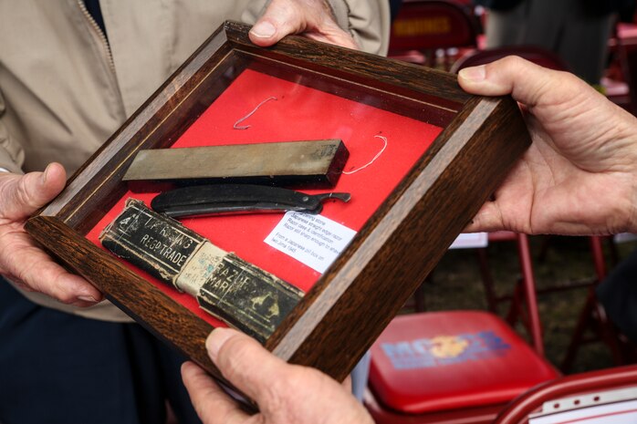 Prior to the opening ceremony, Owen Agenbroad, a Marine veteran and combat message runner during the Battle of Iwo Jima, presents a shadow box to Yoshikau Higuichi March 19 during the annual Reunion of Honor ceremony. The shadow box contained a sharpening stone, Japanese straight-edge razor, razor case, tin cup and identification tags. Agenbroad found these items in a destroyed gun emplacement during the battle and wanted to return them to Higuichi, the son of the fallen Japanese solider they originally belonged to. (U.S. Marine Corps photo by Cpl. Jose D. Lujano/Released)
