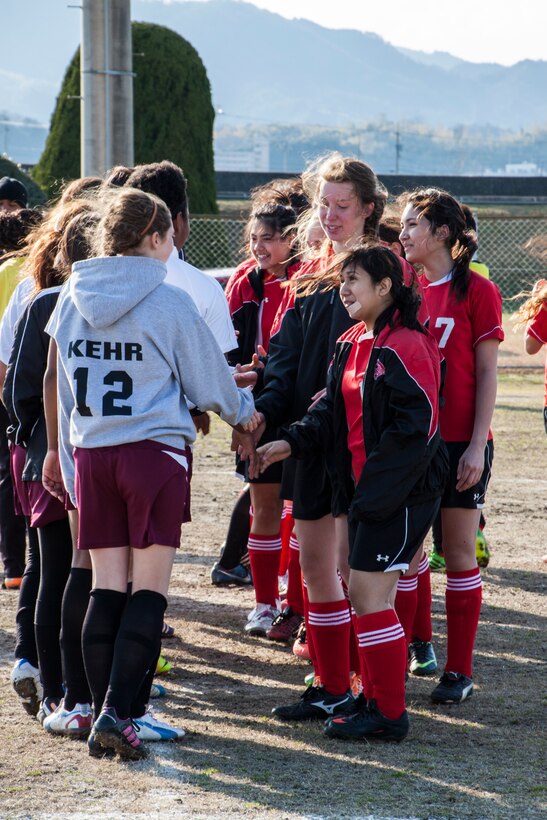 Matthew C. Perry High School Lady Samurai soccer team memberrs and E. J. King High School Lady Cobras soccer team members shake hands after a game that took place at Penny Lake Field aboard Marine Corps Air Station Iwakuni, Japan, March 14, 2014.This game and others played during the weekend marked the beginning of the spring sports season.