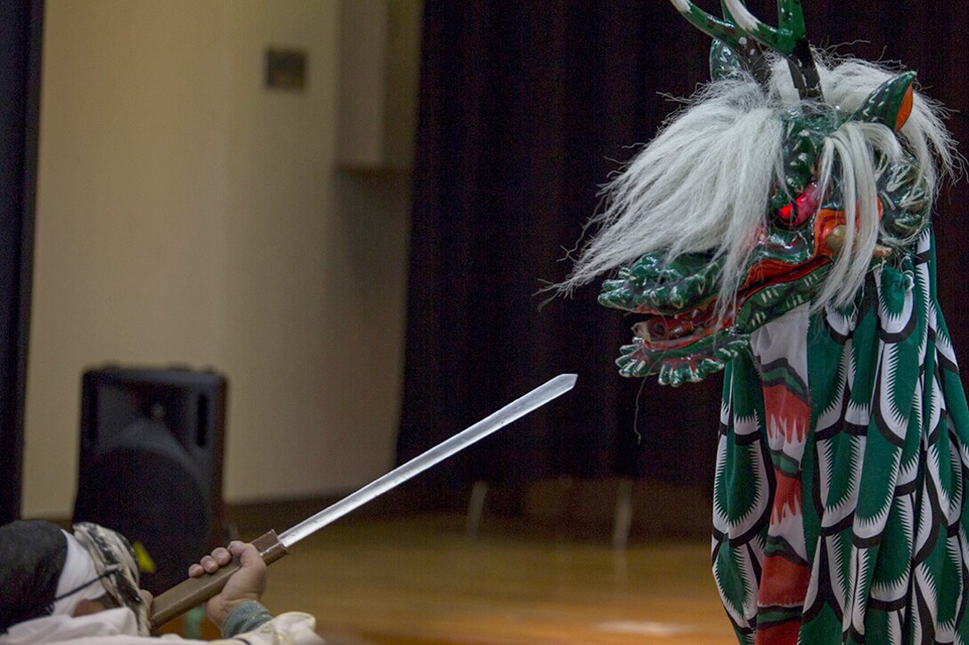 A member of the Fire Dragon Theater, clad in a dragon costume, uses fireworks to portray the beast’s fire-breathing effect during the Kagura performance inside of the Matthew C. Perry High School cafeteria as part of the Japanese American Society Culture Festival, March 8, 2014 aboard, Marine Corps Air Station Iwakuni, Japan. Performers depicted the mythological tale of Yamata-no-Orochi, an eight-headed and eight-tailed serpent.