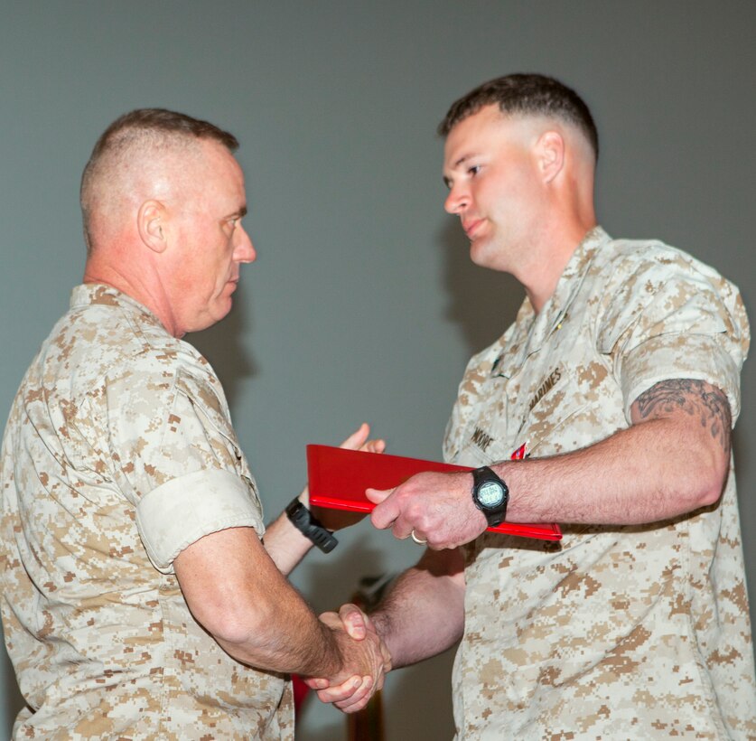 Cpl. Brandon K. Moore, right, receives the Bronze Star Medal with a combat distinguishing device from Maj. Gen. H. Stacy Clardy III March 14 during a ceremony at Camp Schwab, Okinawa, Japan. “Moore was given the opportunity to lead his squad,” said Clardy. “He stepped up and got it done.” Moore is a rifleman with 1st Battalion, 8th Marine Regiment, currently assigned to 4th Marines, 3rd Marine Division, III Marine Expeditionary Force, under the unit deployment program. Clardy is the commanding general of 3rd Marine Division.