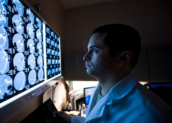 U.S. Air Force Capt. (Dr.) Wesley Reynolds, 99th Medical Operations Squadron neurologist studies a patients computed tomography scan at the Mike O’Callaghan Federal Medical Center March 18, 2014, at Nellis Air Force Base, Nev. March is brain injury awareness month. According to the Brain Injury Association of America, about 75 percent of traumatic brain injuries are concussions or other forms of mild TBI’s. (U.S. Air Force photo by Senior Airman Jason Couillard)