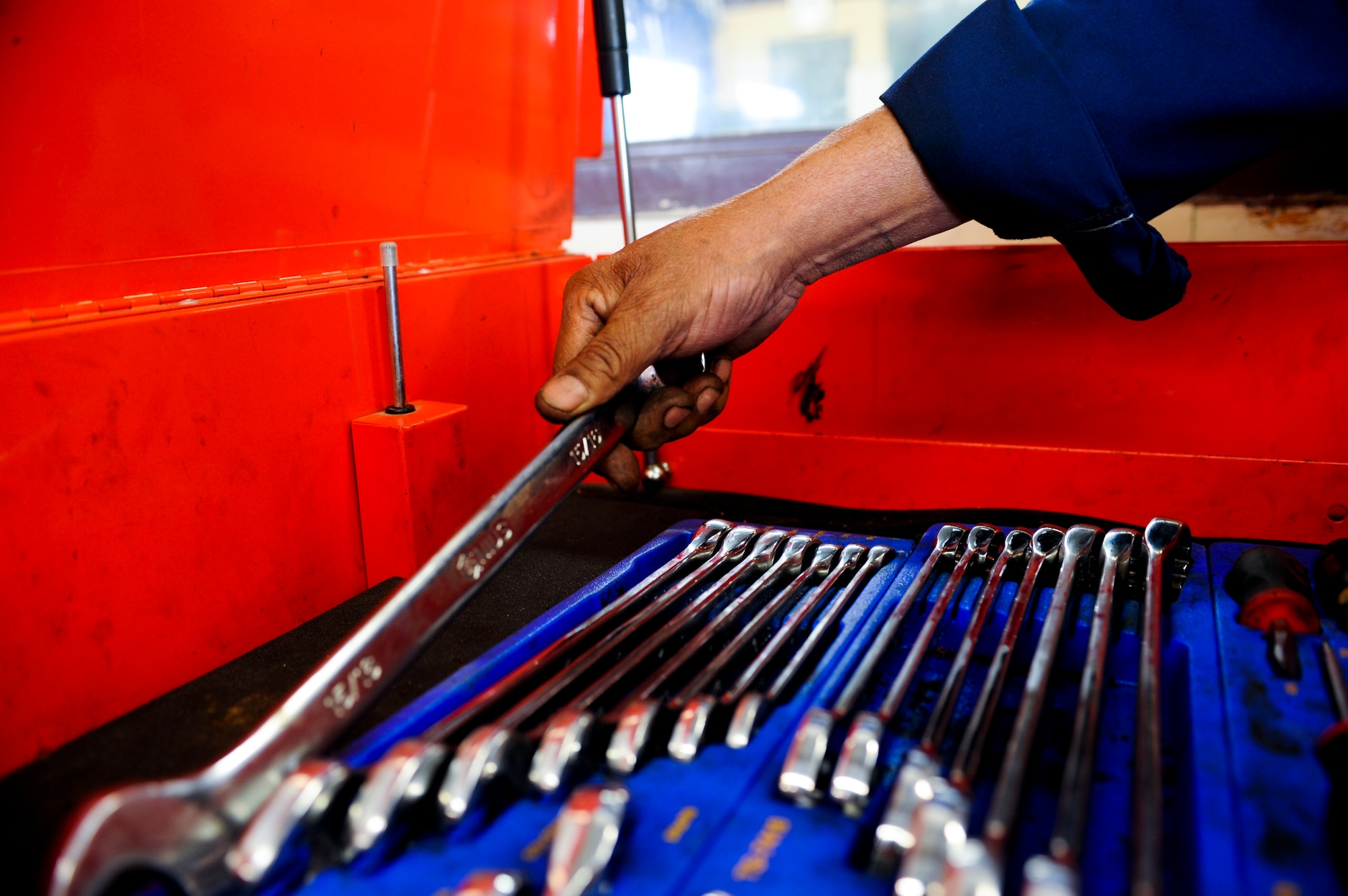 Enrique Kincaid, 355th Force Support Squadron mobile equipment services technician, grabs a wrench for a customer at the Auto Hobby Shop during an inspection at Davis-Monthan Air Force Base, Ariz., March 18, 2014. The Auto Hobby Shop allows D-M Airmen and their families the chance to learn how to work on automobiles from a mechanical advisor or have worked done on their vehicles by one of their civilian mechanics. (U.S. Air Force photo by Senior Airman Sivan Veazie/Released)
