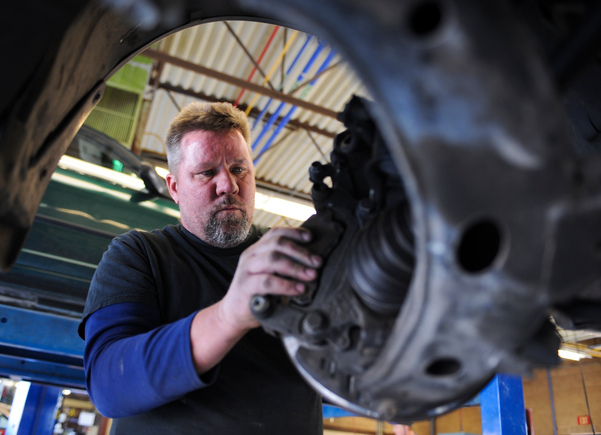 Robert Martin, Auto Hobby Shop contract mechanic, inspects brake pads at the Auto Hobby Shop during an inspection at Davis-Monthan Air Force Base, Ariz., March 18, 2014. Martin has been working as a contract mechanic for the Auto Hobby Shop since 2008. (U.S. Air Force photo by Senior Airman Sivan Veazie/Released)
