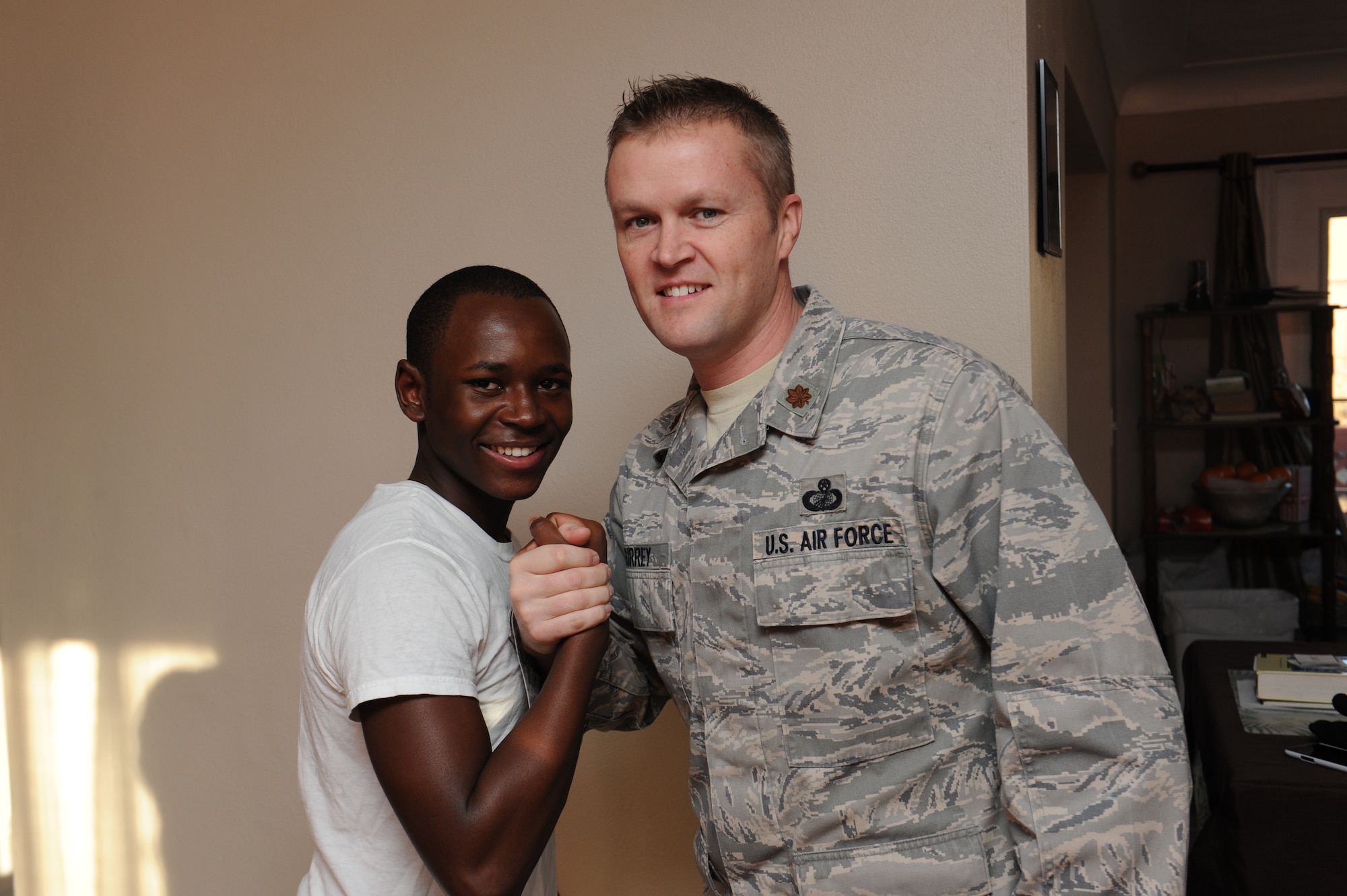 Surrey and his “Little brother”,  Brian, say hello to each other with their signature handshake. They like to eat, compete in sports, watch movies, and play games together at Dave and Busters. (U.S. Air Force photo/ Airman 1st Class Megan Friedl)