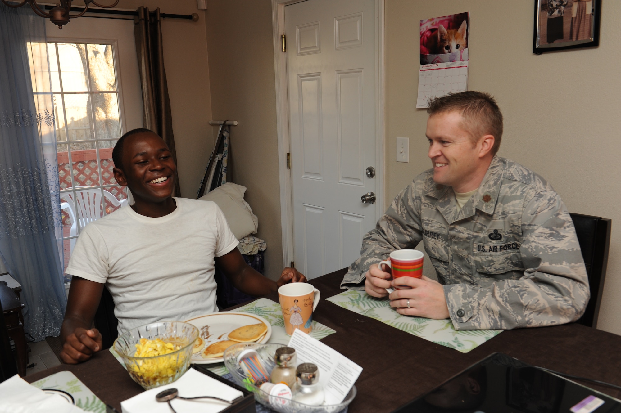 Maj. Robert Surrey and Brian Kalaghe talk and laugh during breakfast before school at Kalaghe’s house.The twohave been matched through Big Brothers Big Sisters for more than two years. Surrey spends his free time mentoring and spending time with Brian and occasionally takes him to school. (U.S. Air Force photo/ Airman 1st Class Megan Friedl)