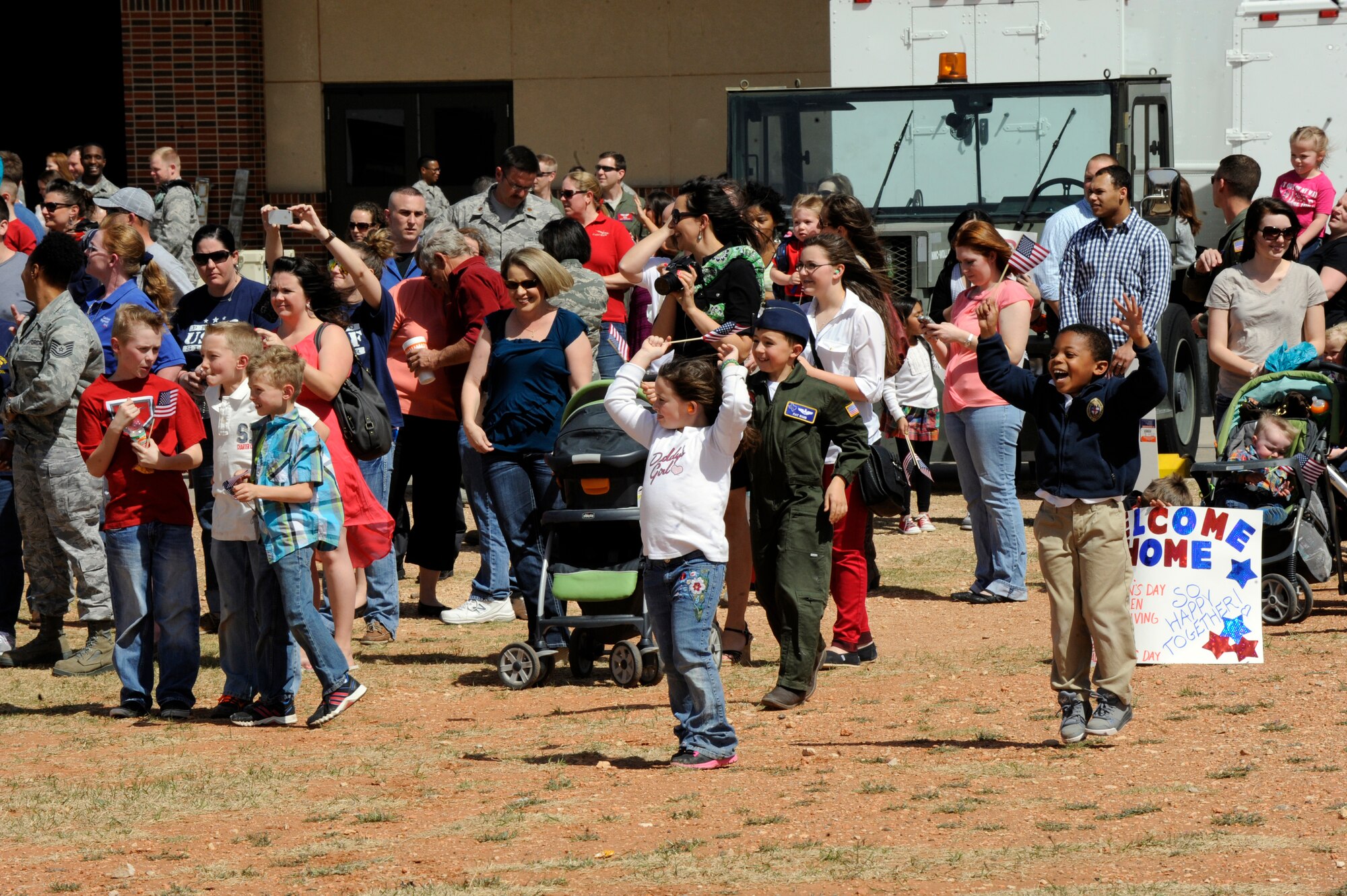 Friends and family of deployed members of the 39th Airlift Squadron anxiously wait as the first C-130J touches down March 18, 2014, at Dyess Air Force Base, Texas. The squadron was deployed for six months supporting operations in Afghanistan. (U.S. Air Force photo by Airman 1st Class Alexander Guerrero/Released)