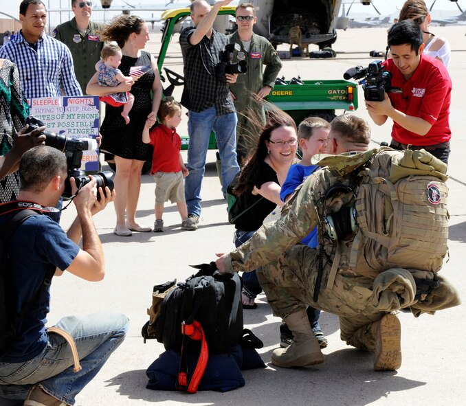 An Airman from the 39th Airlift Squadron is greeted by his family after returning home from a deployment March 18, 2014, at Dyess Air Force Base, Texas. In September 2013, more than 170 Airmen deployed for six months in support of combat operations in Afghanistan. (U.S. Air Force photo by Airman 1st Class Alexander Guerrero/Released)