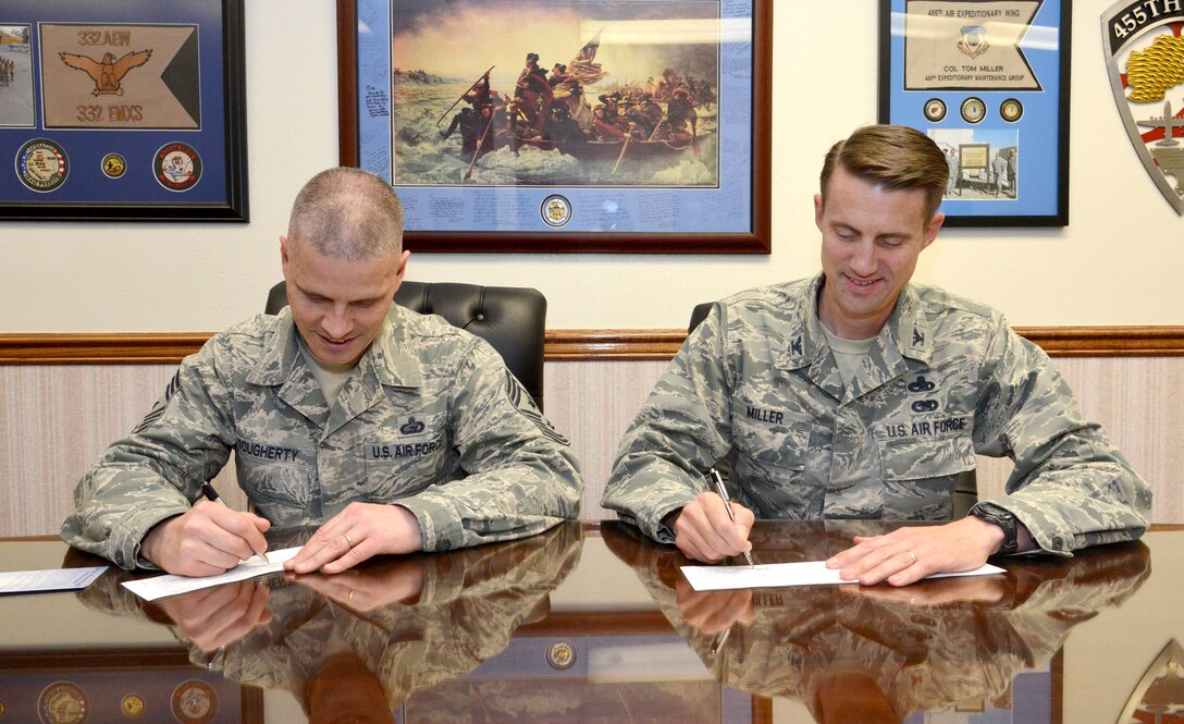 Col. Tom Miller, 377th Air Base Wing commander, right, and Chief Master
Sgt. John A. Dougherty, 377th ABW command chief, sign donation forms
for the Air Force Assistance Fund. (Photo by Ken Moore)