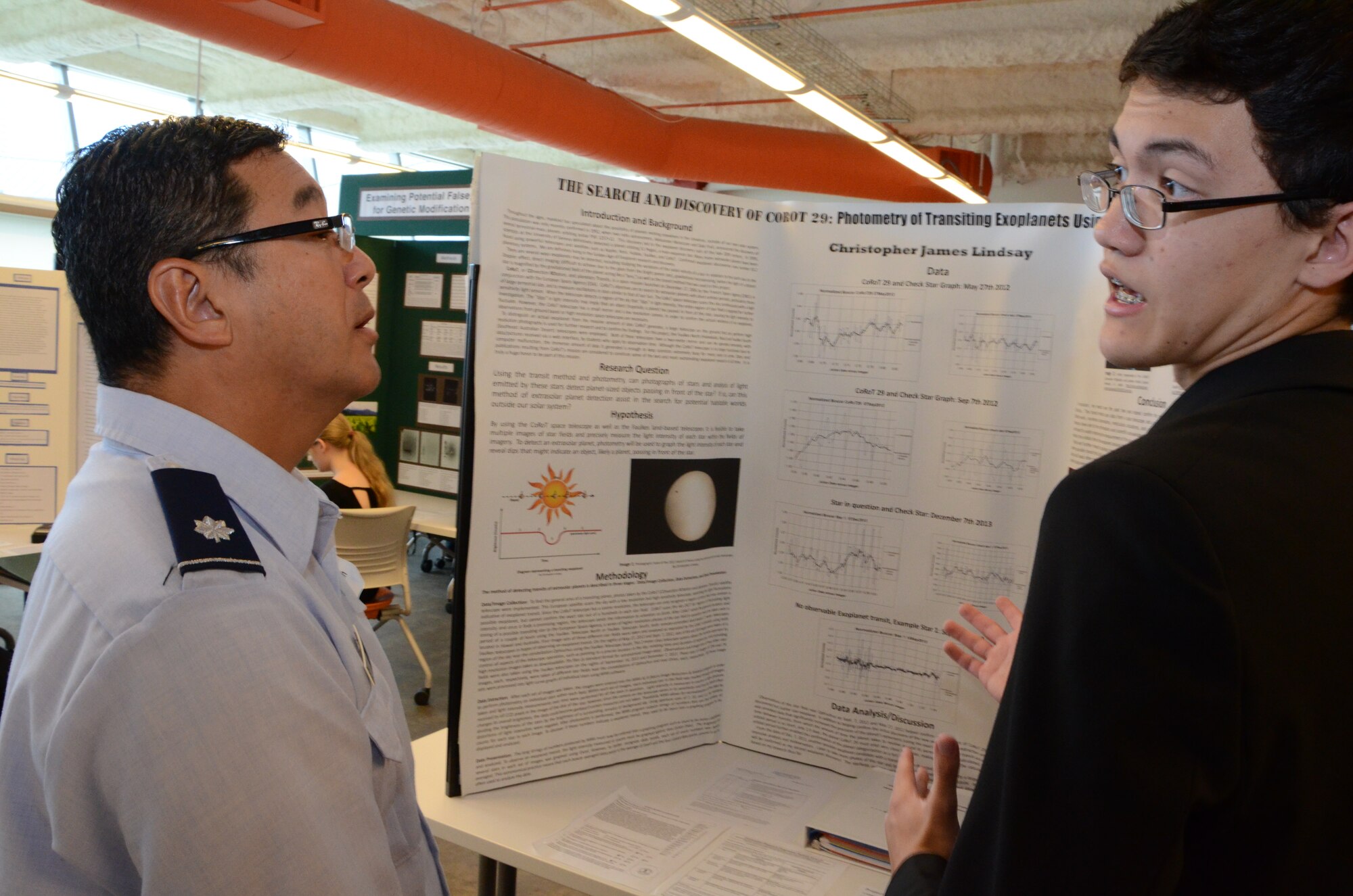 Lt. Col. Nathan Kwon, left, a Critical Care Air Transport Team (CCATT) physician with the 624th Aeromedical Staging Squadron, Joint Base Pearl Harbor-Hickam, Hawaii, listens to Christopher, right, a high school student, explain the premise of his research project at the Hawaii Association of Independent Schools (HAIS) District Science & Engineering Fair held at Ioloni School, Honolulu, Hawaii, Feb. 8, 2014. Christopher not only advanced to the state-level competition, but was one of two students selected to attend the Intel International Science and Engineering Fair (Intel ISEF) in Los Angeles, Calif., in May—the world’s largest international pre-college science competition. (U.S. Air Force photo by Tech. Sgt. Phyllis Keith)