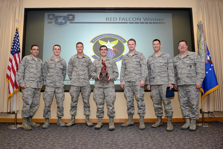 The 4th Space Operations Squadron Alpha Crew members receive the RED FALCON trophy during an award ceremony March 13, 2014, at Schriever Air Force Base, Colo. RED FALCON was designed to inspire 50th Space Wing crews to develop system expertise that exceeds surface checklist knowledge, foster the normalization of non-routine mission protection procedures and identify the 50th Operations Group crew best prepared to operate in ill-defined emergency situations. (U.S. Air Force photo/Christopher DeWitt)