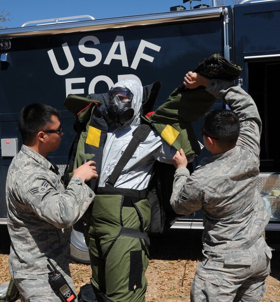 Senior Airman Alex Gaunt and Airman 1st Class Alexander Trippett both 2nd Civil Engineer Squadron Explosive Ordnance Disposal technicians, place a EOD 9 suit on Staff Sgt. Timothy Ostberg, 2nd CES EOD technician, on Barksdale Air Force Base, La., March 13, 2014.  EOD Airmen wear the suit to provide protection for a possible detonation of a bomb. (U.S. Air Force photo/Senior Airman Joseph A. Pagán Jr.)