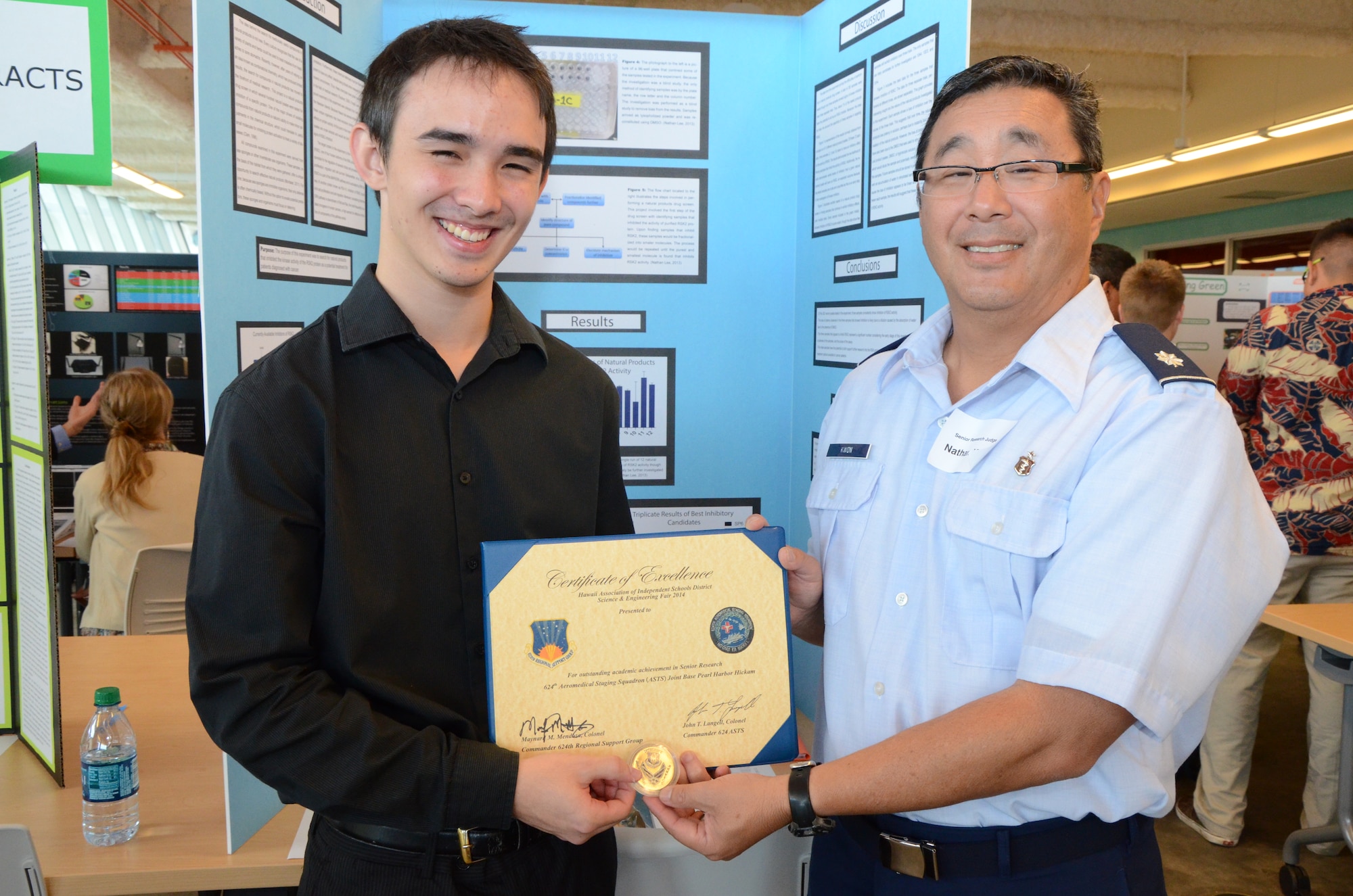 Lt. Col. Nathan Kwon, right, a Critical Care Air Transport Team (CCATT) physician with the 624th Aeromedical Staging Squadron, Joint Base Pearl Harbor-Hickam, Hawaii, presents an achievement award on behalf of his Air Force Reserve unit to a senior at Kamehameha Schools, Nathan, left, at the Hawaii Association of Independent Schools (HAIS) District Science & Engineering Fair held at Ioloni School, Honolulu, Hawaii, Feb. 8, 2014. Kwon’s role as a judge at the fair was to support and encourage achievements of Hawaii's youth in science, technology, engineering, math, and medicine (STEMM). Nathan advanced to the state-level competition. (U.S. Air Force photo by Tech. Sgt. Phyllis Keith)