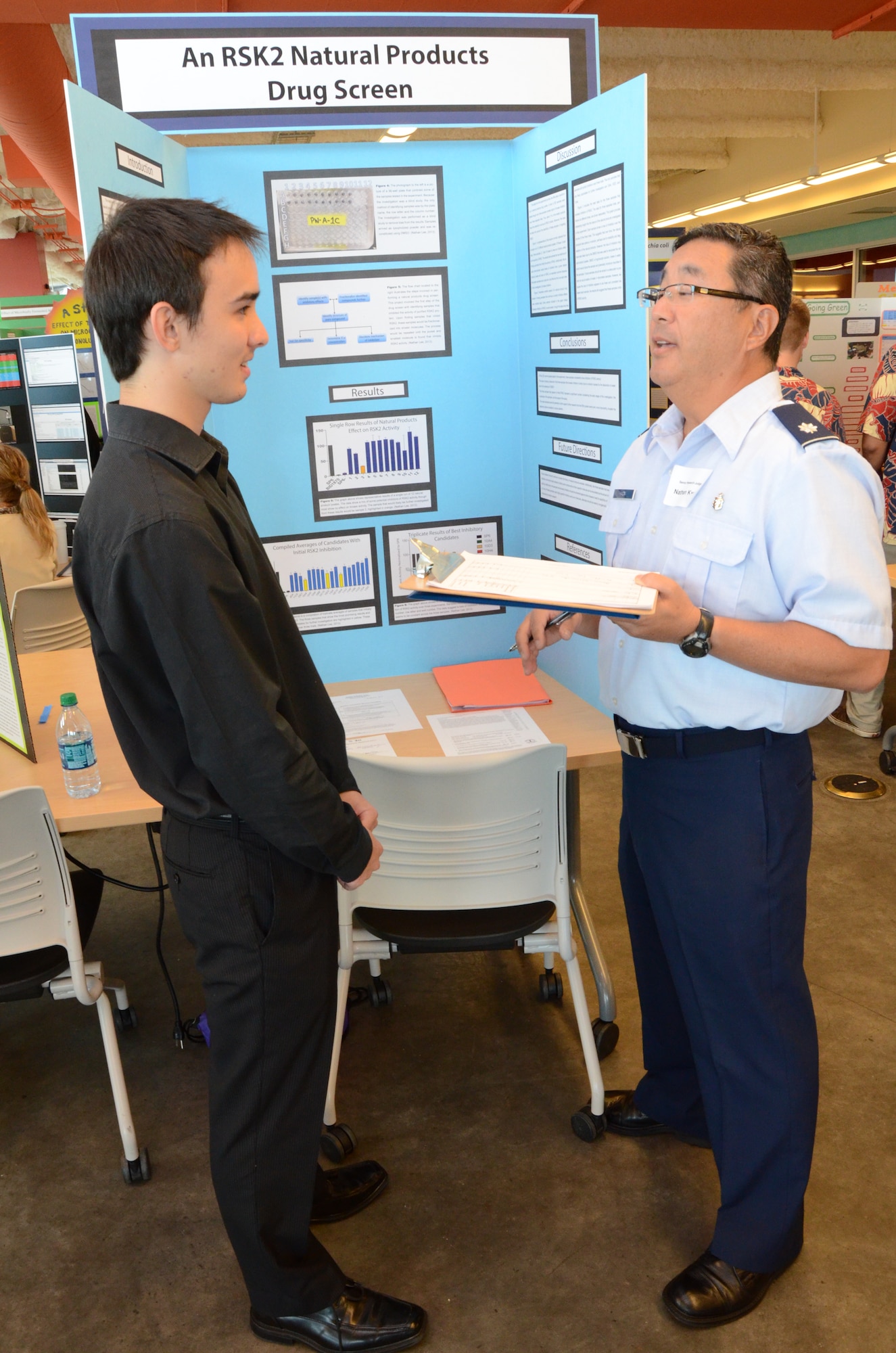 Lt. Col. Nathan Kwon, right, a Critical Care Air Transport Team (CCATT) physician with the 624th Aeromedical Staging Squadron, Joint Base Pearl Harbor-Hickam, Hawaii, talks to Nathan, left, a high school student, about his research project at the Hawaii Association of Independent Schools (HAIS) District Science & Engineering Fair held at Ioloni School, Honolulu, Hawaii, Feb. 8, 2014. Kwon, a judge at the fair, said Nathan demonstrated a clear understanding about the complex protocol and modified it with his own ideas. Nathan said, “My project was trying to find natural products—extracts from plants and organisms—to see if they had any effect on a specific protein known as RSK2. The ultimate goal of this was to try and find new drugs and patients diagnosed with cancer have more options for treatment.” (U.S. Air Force photo by Tech. Sgt. Phyllis Keith)
