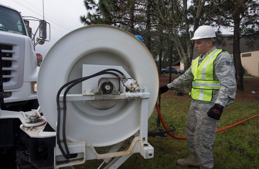 U.S. Air Force Senior Airman Robert Kost, 23d Civil Engineer Squadron water and fuel system maintenance technician, raises a water hose at Moody Air Force Base, Ga., March 18, 2014. Airmen from the 23d CES water and fuel system maintenance are also responsible for resolving power line and natural gas issues on base. (U.S. Air Force photo by Airman Dillian Bamman/Released)