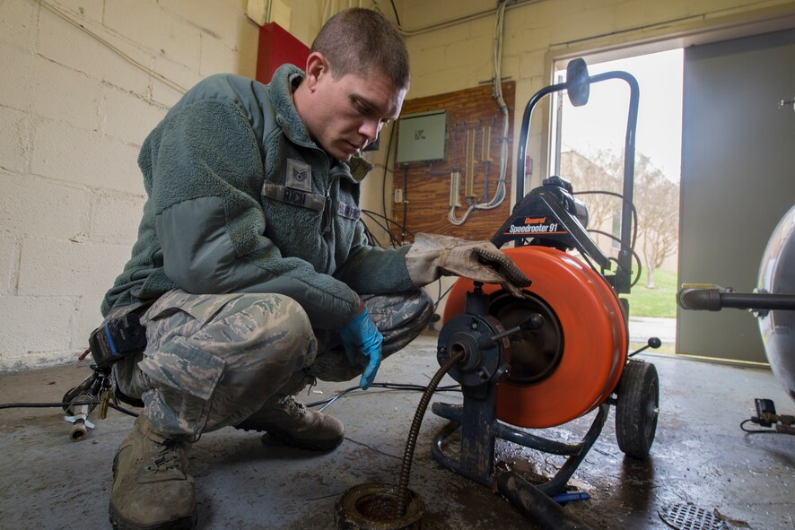 U.S. Air Force Tech. Sgt. Jeremy Rich, 23d Civil Engineer Squadron water and fuel system maintenance technician, unclogs a drain pipe with a pipe cleaner at Moody Air Force Base, Ga., March 7, 2014. The pipe cleaner auto-feeds a metal cable into the drain pipe and spins to resolve any suspected clogs. (U.S. Air Force photo by Airman Dillian Bamman/Released)