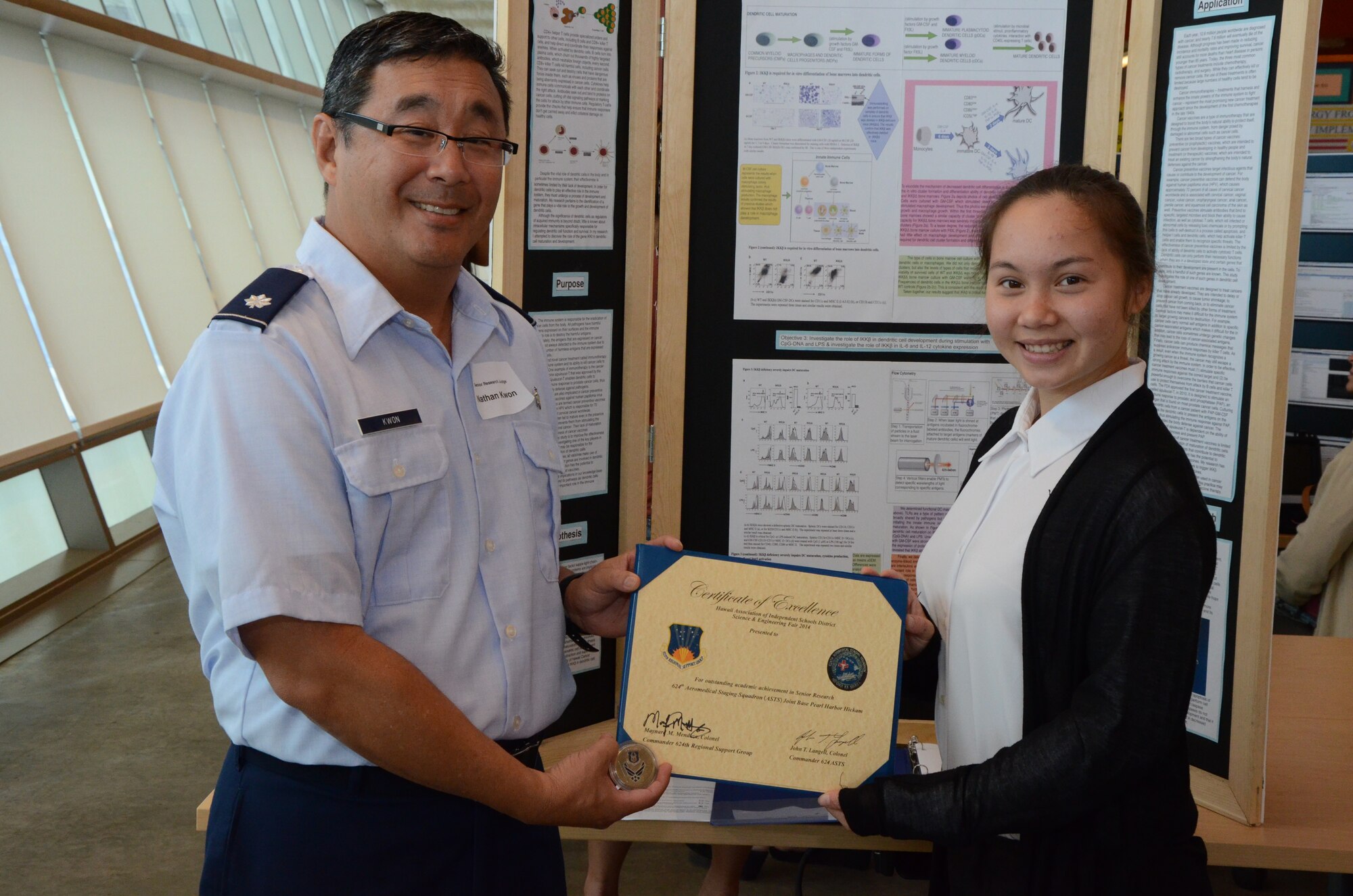 Lt. Col. Nathan Kwon, left, a Critical Care Air Transport Team (CCATT) physician with the 624th Aeromedical Staging Squadron, Joint Base Pearl Harbor-Hickam, Hawaii, presents an achievement award on behalf of his Air Force Reserve unit to a high school student, Anna, right, at the Hawaii Association of Independent Schools (HAIS) District Science & Engineering Fair held at Ioloni School, Honolulu, Hawaii, Feb. 8, 2014. Kwon, a judge at the fair, chose Anna’s project, “Identifying a Gene Responsible for Maturation of Dendritic Cells of the Mammalian Immune System,” for the sophistication of her research in the field of medicine. Anna not only advanced to the state-level competition, but was one of two students selected to attend the Intel International Science and Engineering Fair (Intel ISEF) in Los Angeles, Calif., in May—the world’s largest international pre-college science competition.  (U.S. Air Force photo by Tech. Sgt. Phyllis Keith)