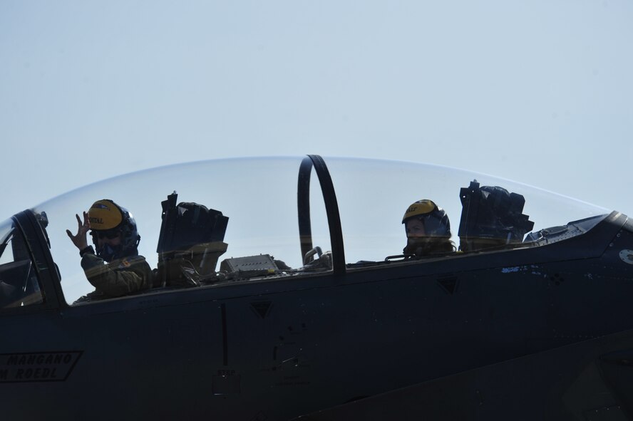 An F-15E Strike Eagle pilot and weapons system officer, from the 336th Fighter Squadron, wave to families waiting on the flight line, March 15, 2014, at Seymour Johnson Air Force Base, N.C. The 336th FS Airmen were returning from Nellis Air Force Base, Nev., where they were the host wing for Red Flag 14-2. (U.S. Air Force photo/Airman 1st Class Shawna L. Keyes)