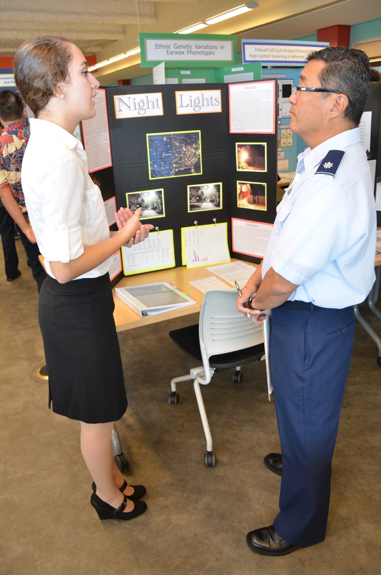 Lt. Col. Nathan Kwon, right, a Critical Care Air Transport Team (CCATT) physician with the 624th Aeromedical Staging Squadron, Joint Base Pearl Harbor-Hickam, Hawaii, listens to a high school student, left, explain the premise of her research project at the Hawaii Association of Independent Schools (HAIS) District Science & Engineering Fair held at Ioloni School, Honolulu, Hawaii, Feb. 8, 2014. Kwon, a judge at the fair, was not only supporting and encouraging achievements of Hawaii's youth in science, technology, engineering, math, and medicine (STEMM), but representing the Air Force Science Fair Program based at Wright-Patterson Air Force Base, Dayton, Ohio, whose three goals are: to demonstrate Air Force interest in youth to the community; to recognize and encourage students who are conducting research in areas of interest to the Air Force; and to acquaint students with Air Force career possibilities by providing Air Force visibility to potential future scientists and engineers. (U.S. Air Force photo by Tech. Sgt. Phyllis Keith)