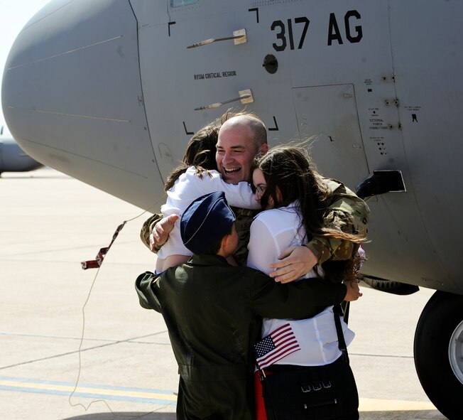 U.S. Air Force Maj. Patrick Sims, 39th Airlift Squadron, reaches for his son during a welcome home ceremony March 18, 2014, at Dyess Air Force Base, Texas. Airmen from the 39th AS operated in various parts of Afghanistan supporting theater commanders' requirements with combat-delivery capabilities through tactical air-land and air-drop operations. (U.S. Air Force photo by Airman 1st Class Kedesha Pennant/Released)