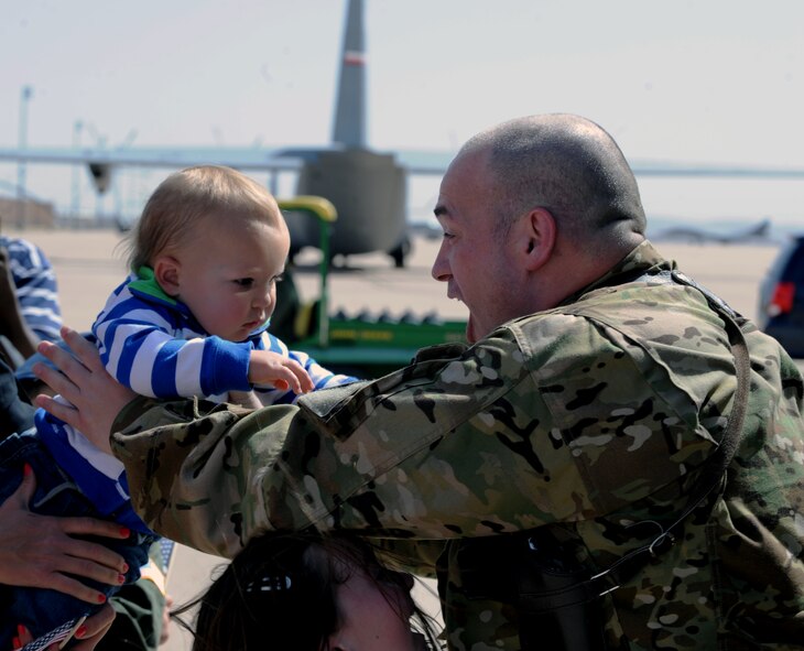 U.S. Air Force Maj. Patrick Sims, 39th Airlift Squadron, reaches for his son during a welcome home ceremony March 18, 2014, at Dyess Air Force Base, Texas. Airmen from the 39th AS operated in various parts of Afghanistan supporting theater commanders' requirements with combat-delivery capabilities through tactical air-land and air-drop operations. (U.S. Air Force photo by Airman 1st Class Kedesha Pennant/Released)