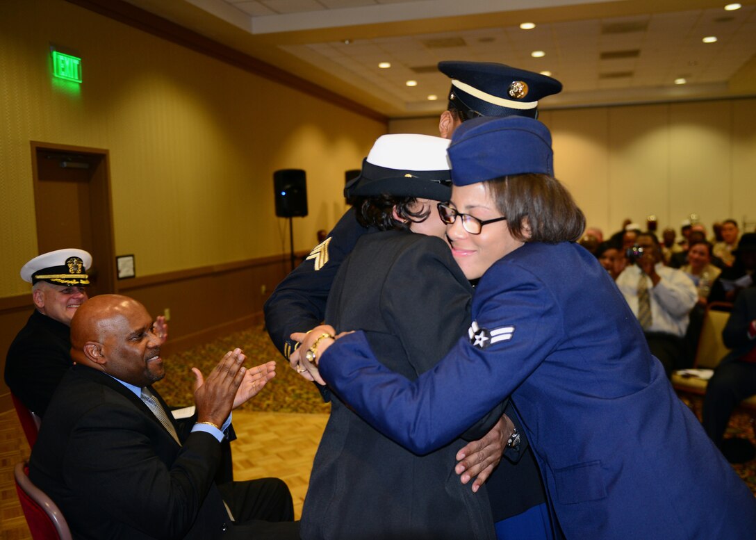 U.S. Navy Chief Petty Officer Twanna Edwards shares a moment with her daughter, U.S. Air Force Airman 1st Class Kedesha Pennant, 7th Bomb Wing, and brother, U.S. Army Sgt. Brandon Burke, at her retirement ceremony March 7, 2014, at Naval Station Norfolk, Va.  Edwards gave a farewell speech reminiscing about the day she took a bus to an unknown world to start a new chapter in her life to the days leading up to her retirement ceremony. (U.S. Navy Photo by Mass Communication Specialist 3rd Class Amber O'Donovan/Released)