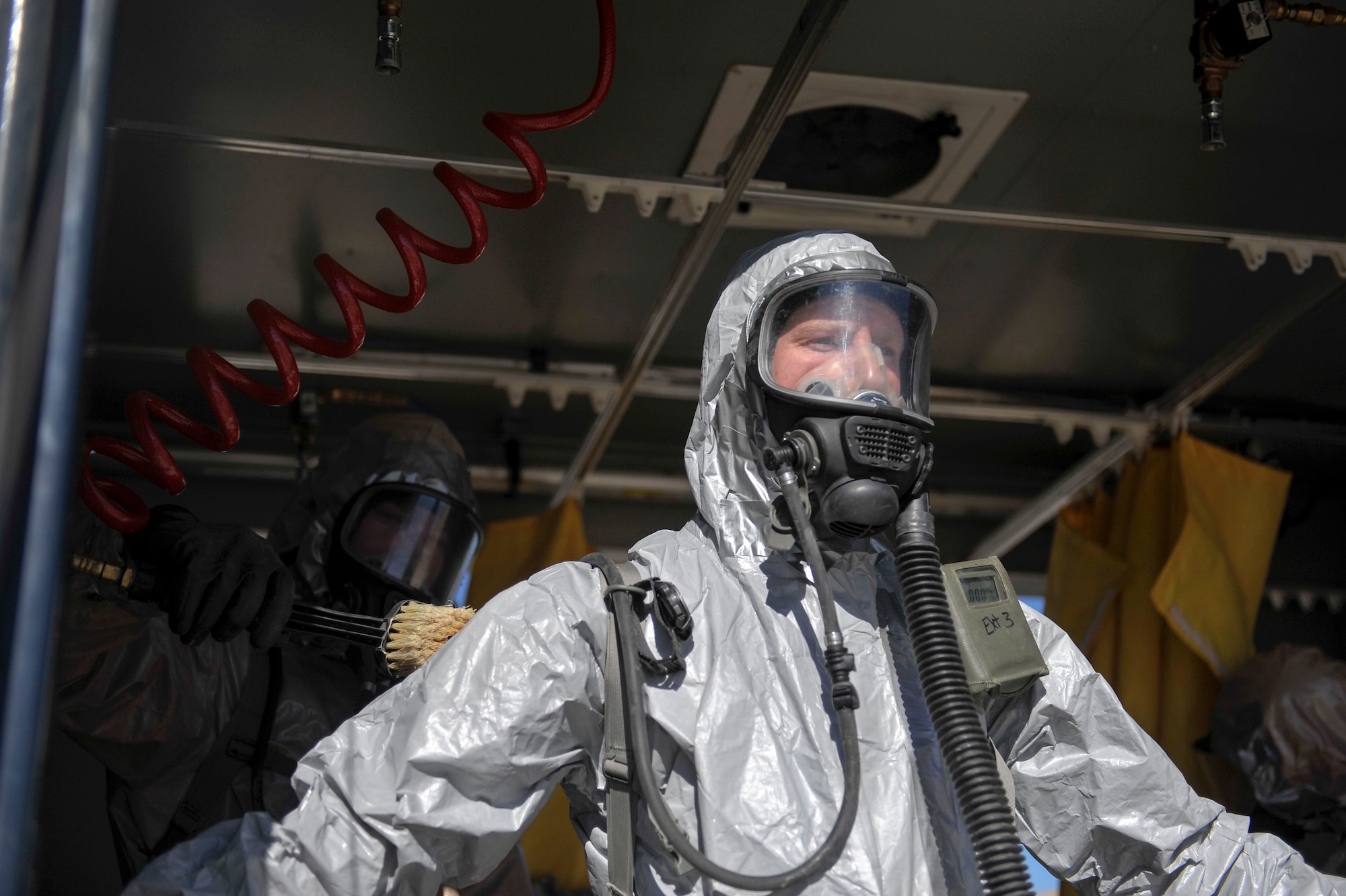 Colorado National Guard Chemical, Biological, Radiological, Nuclear and High-Yield Explosive Enhanced Response Force Package search and rescue team member stands in the decontamination tent to be cleaned during an exercise March 8, 2014, in Lakewood, Colo. The CERFP team spends one weekend every three months training in an emergency exercise to refine their skills in search and rescue, decontamination and medical procedures. (U.S Air Force photo by Airman 1st Class Samantha Saulsbury/Released)