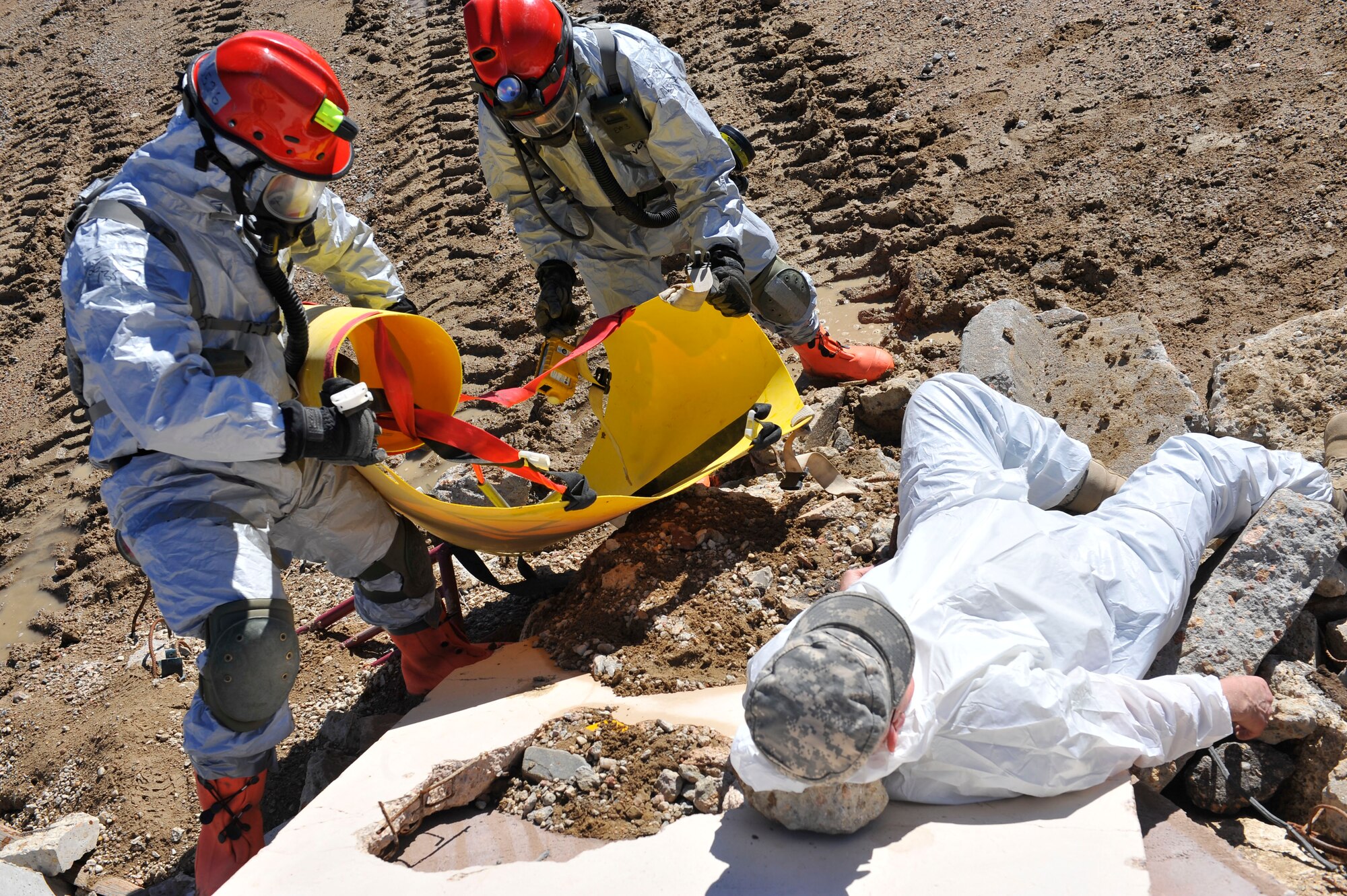 Colorado National Guard Chemical, Biological, Radiological, Nuclear and High-Yield Explosive Enhanced Response Force Package search and rescue members place a gurney next to a simulated victim to safely move him to the decontamination unit during an exercise March 8, 2014 in Lakewood, Colo. The CERFP team spends one weekend every three months training in an emergency exercise to refine their skills in search and rescue, decontamination and medical procedures. (U.S Air Force photo by Airman 1st Class Samantha Saulsbury/Released)