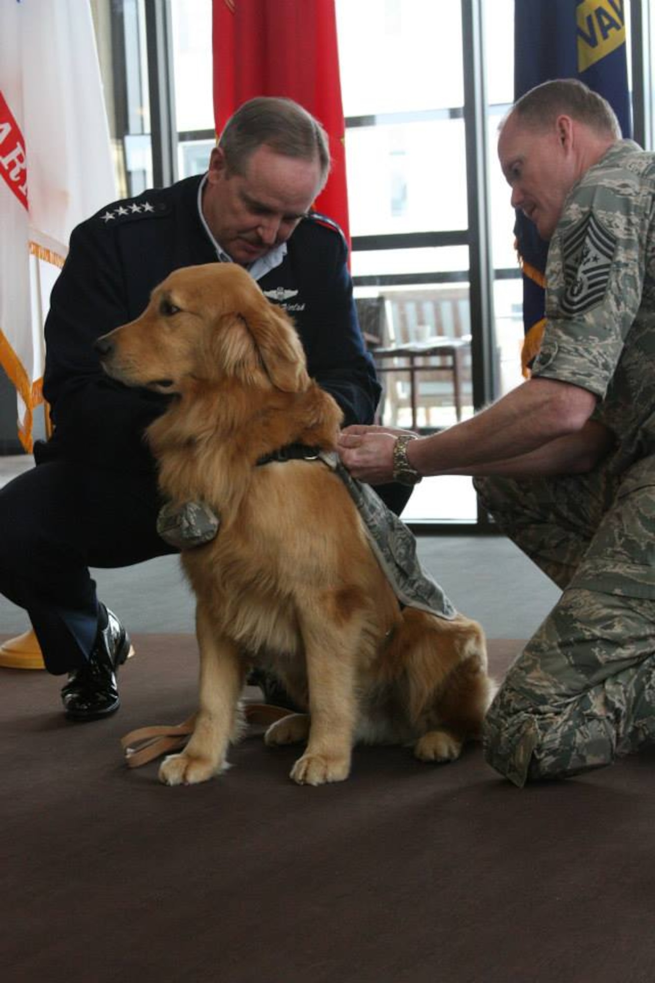 The Air Force Chief of Staff, Gen. Mark A. Welsh III, and Chief Master Sgt. of the Air Force, James A. Cody, commission Goldie, a Golden Retriever’s as a second lieutenant in the therapy dog programat at Walter Reed National Military Medical Center on March 12. (Photo by Bernard S. Little)