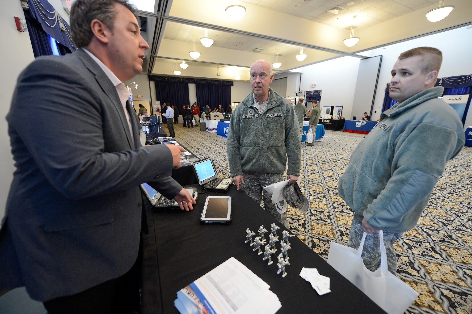 Scott Beard of Intelligent Decisions, left, talks with Senior Master Sgt. Vincent Alios, right, and Master Sgt. Doug Westover, center, both of the 512th Maintenance Squadron about ruggedized laptops and electronic tablets during the 2014 Dover Air Force Base Technology Exposition at The Landings Club, March 18, 2014, at Dover Air Force Base, Del. The expo was hosted by the 436th Communications Squadron to allow exhibitors to showcase their products with potential customers from across the base. (U.S. Air Force photo/Greg L. Davis)
